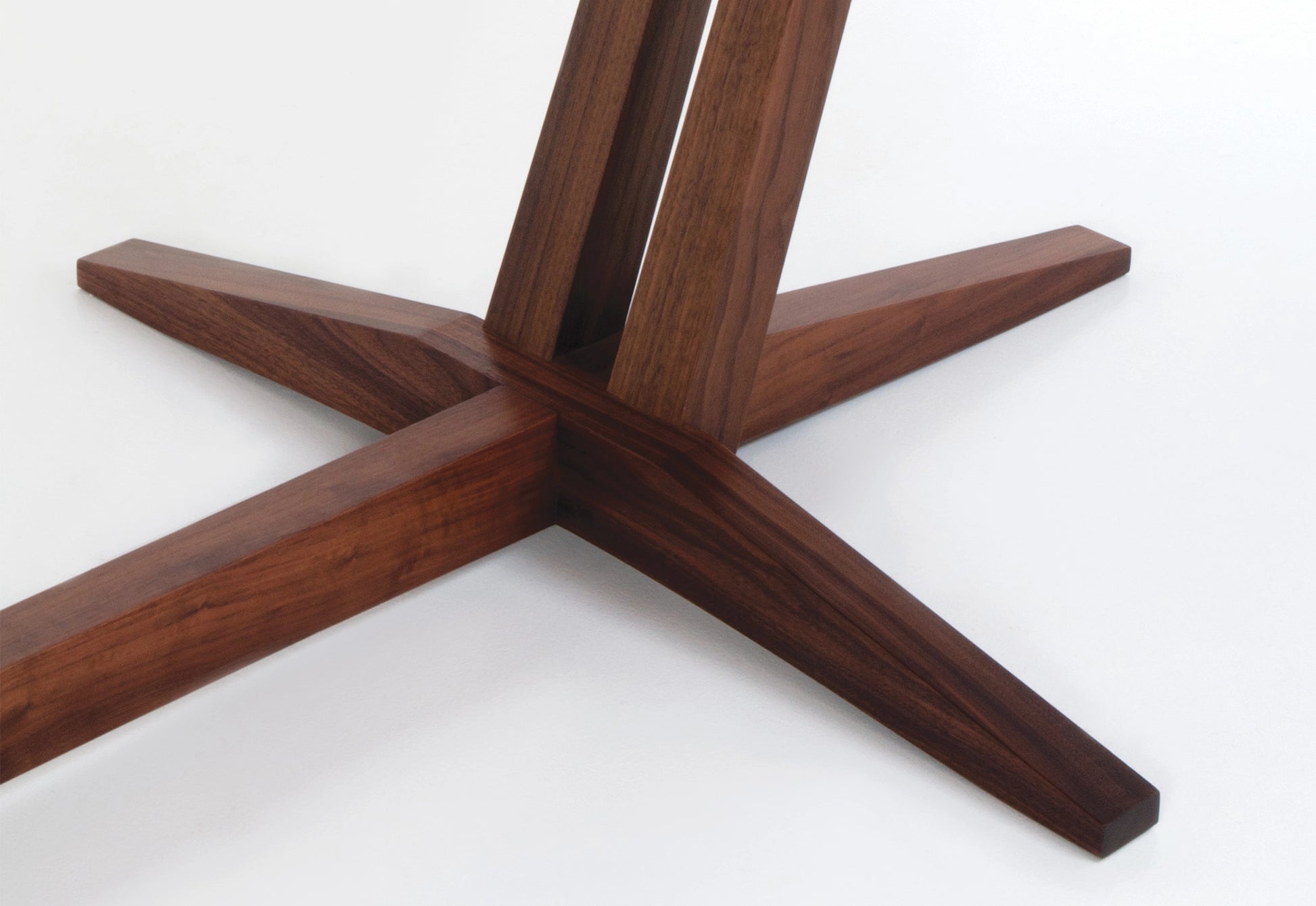 Wooden table base with star-shaped design on a white background