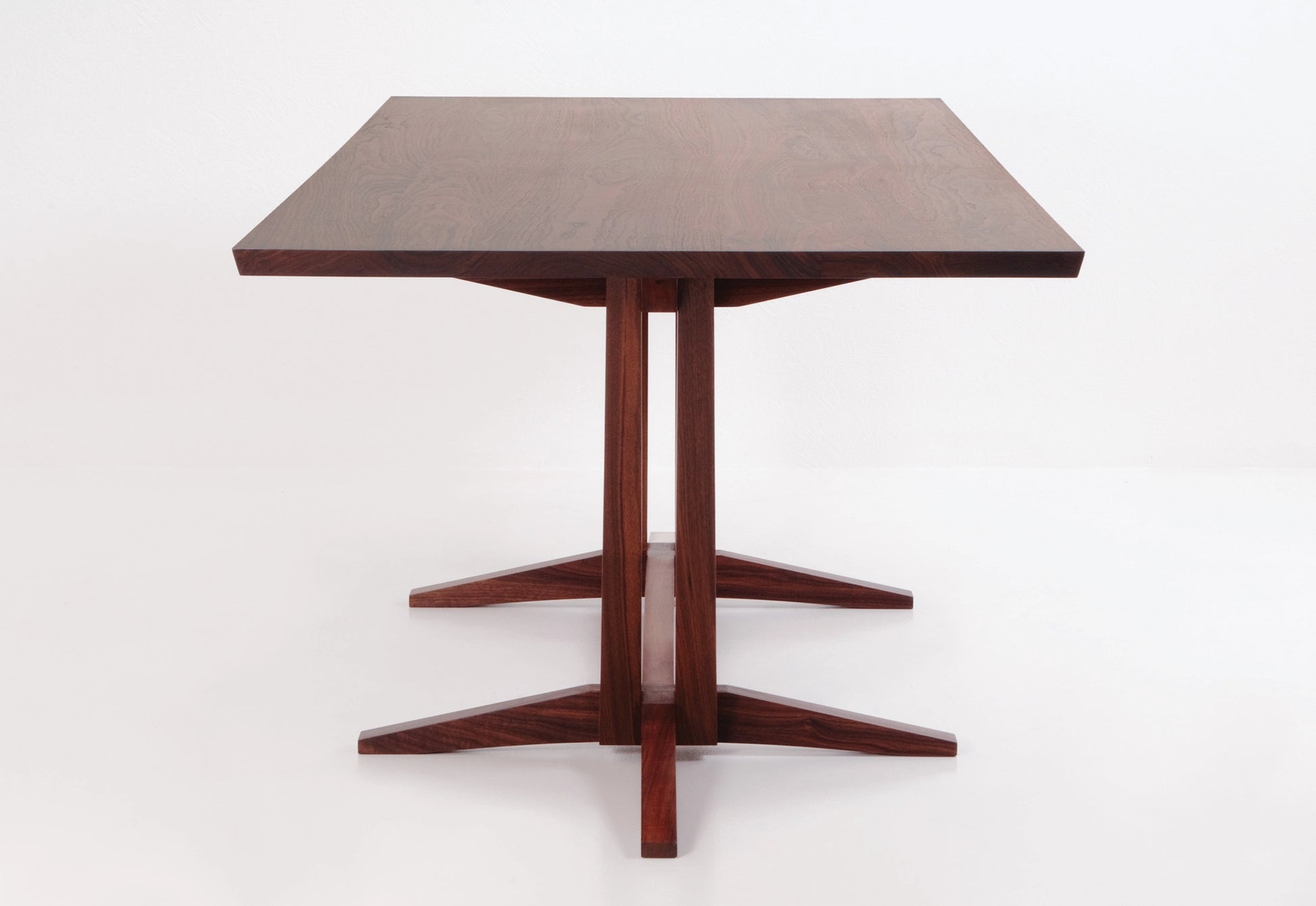 Wooden table with a star-shaped base on a white background