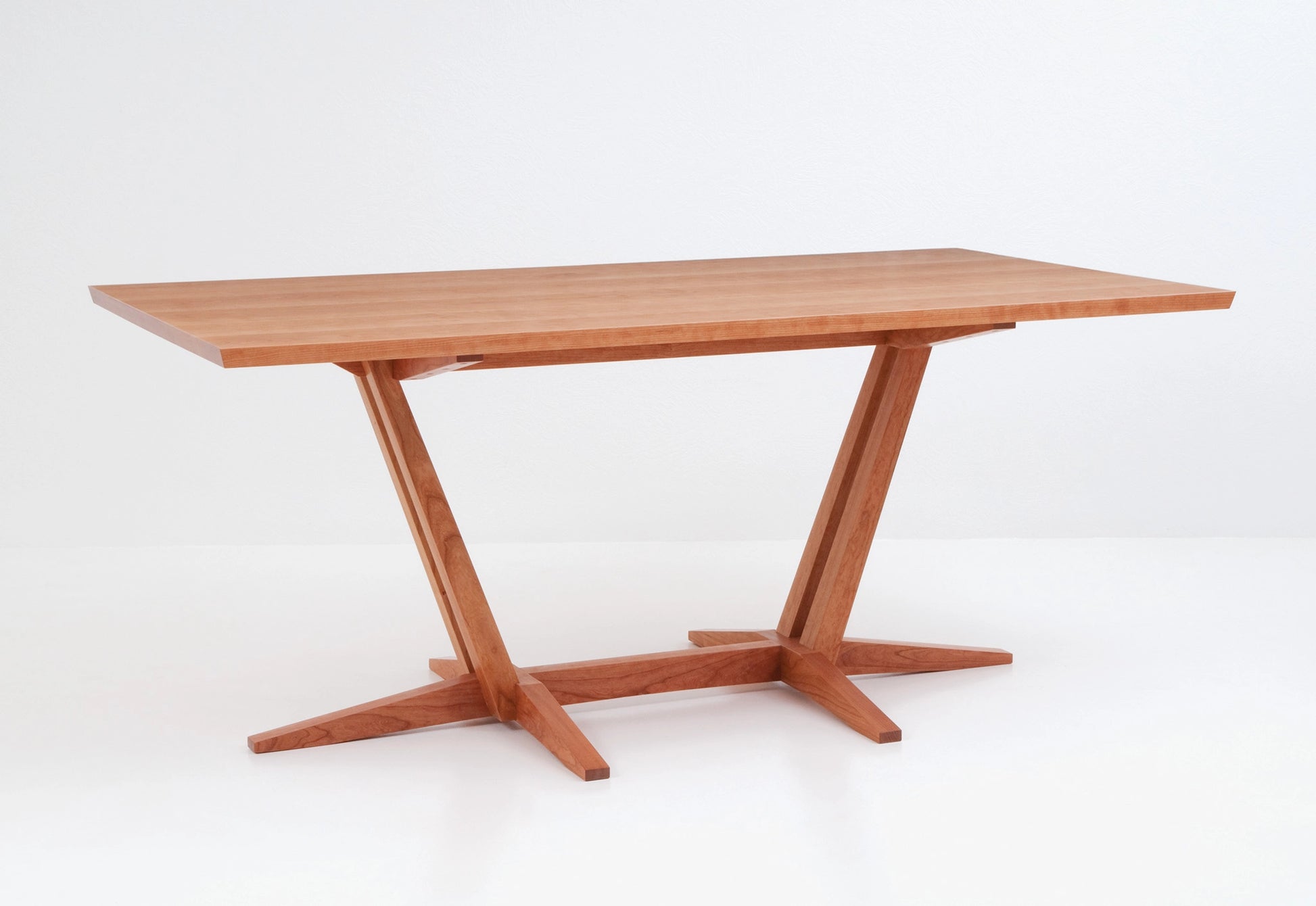 Wooden dining table with a minimalist design on a white background
