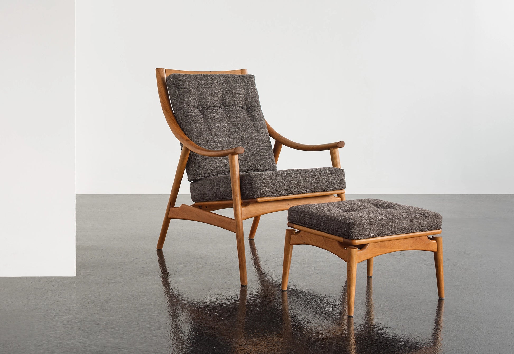 Wooden armchair with gray cushions on a reflective surface