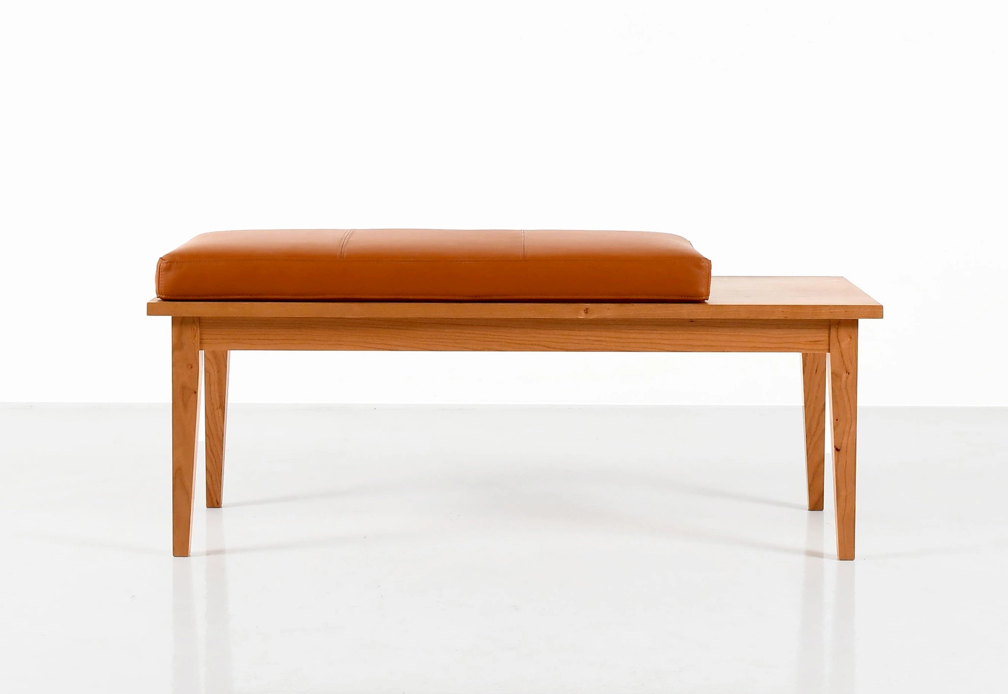 Wooden bench with a brown cushion on a white background
