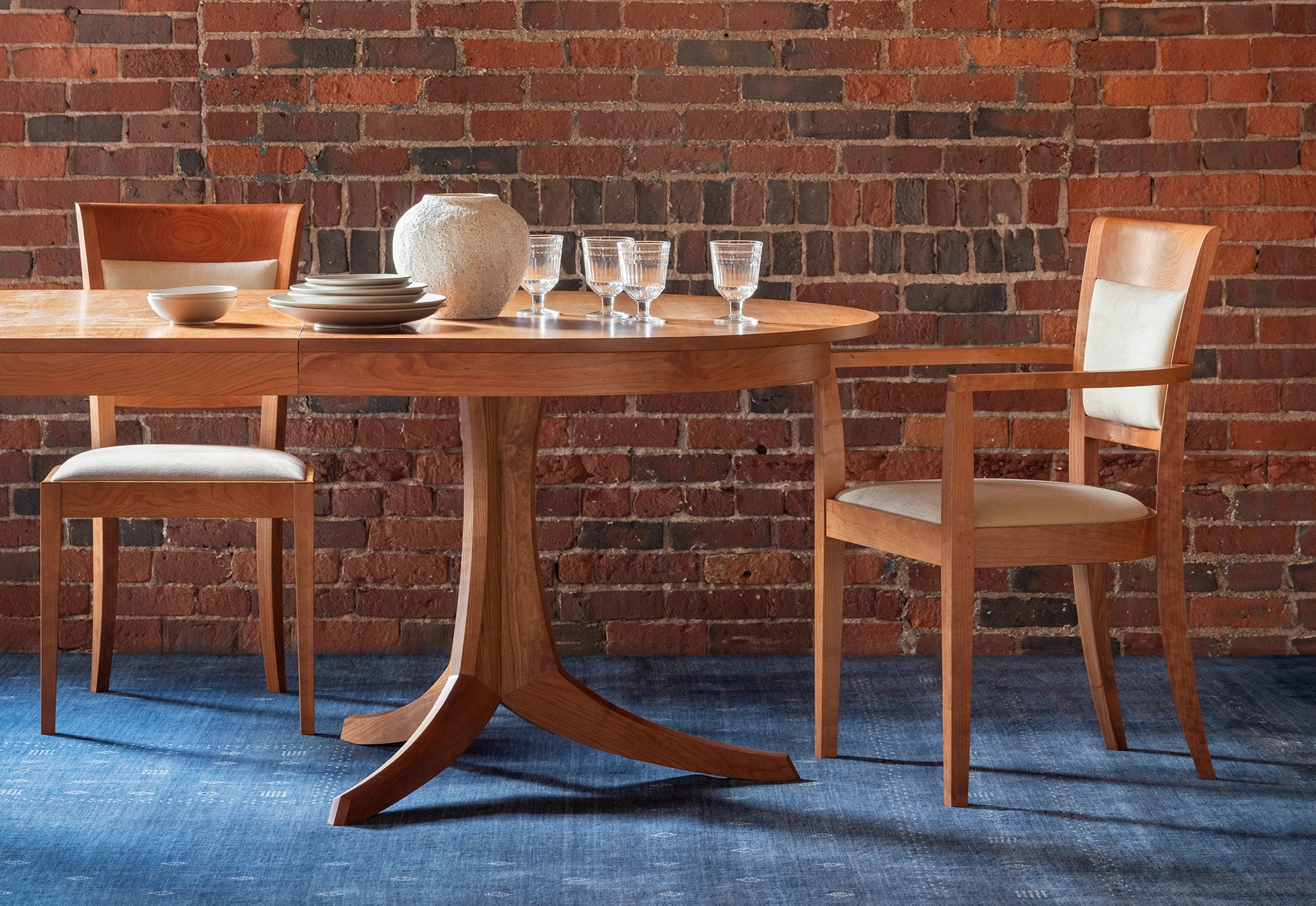 Dining table with chairs against a brick wall
