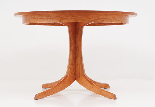 Wooden round table with a pedestal base on a white background