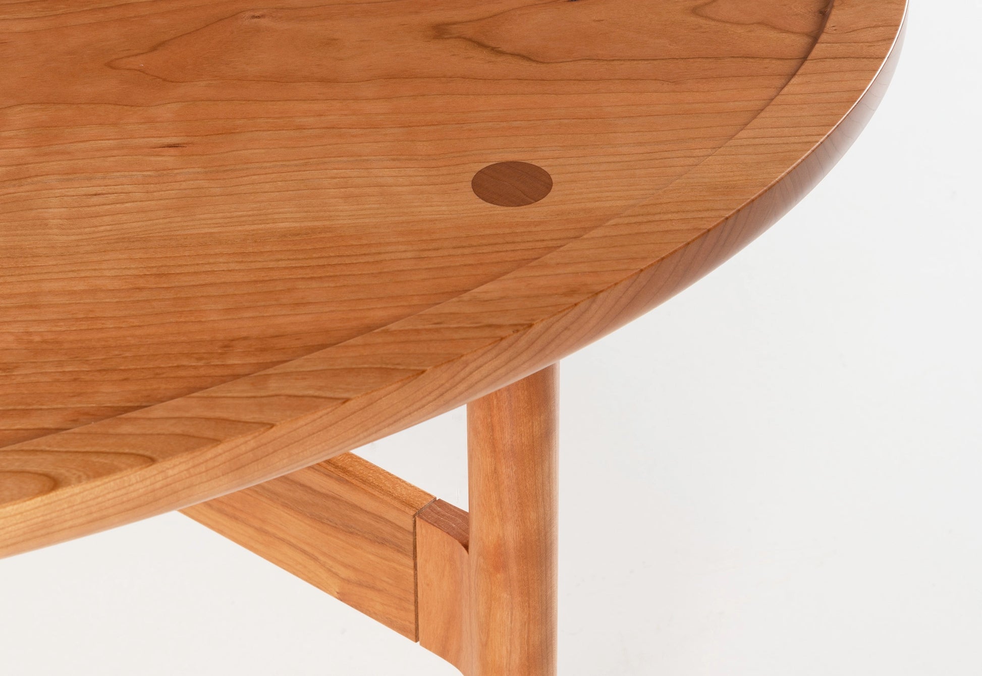 Detail of a cherry coffee table on a white background.