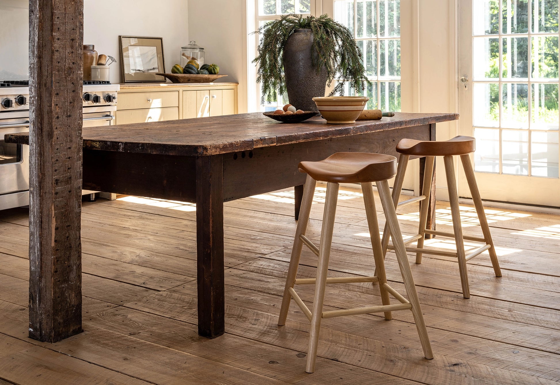 Wooden kitchen island with stools in a bright kitchen setting