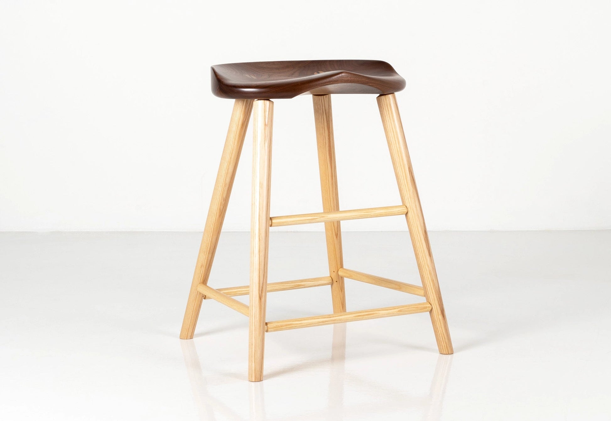 Wooden bar stool with a dark brown seat on a white background
