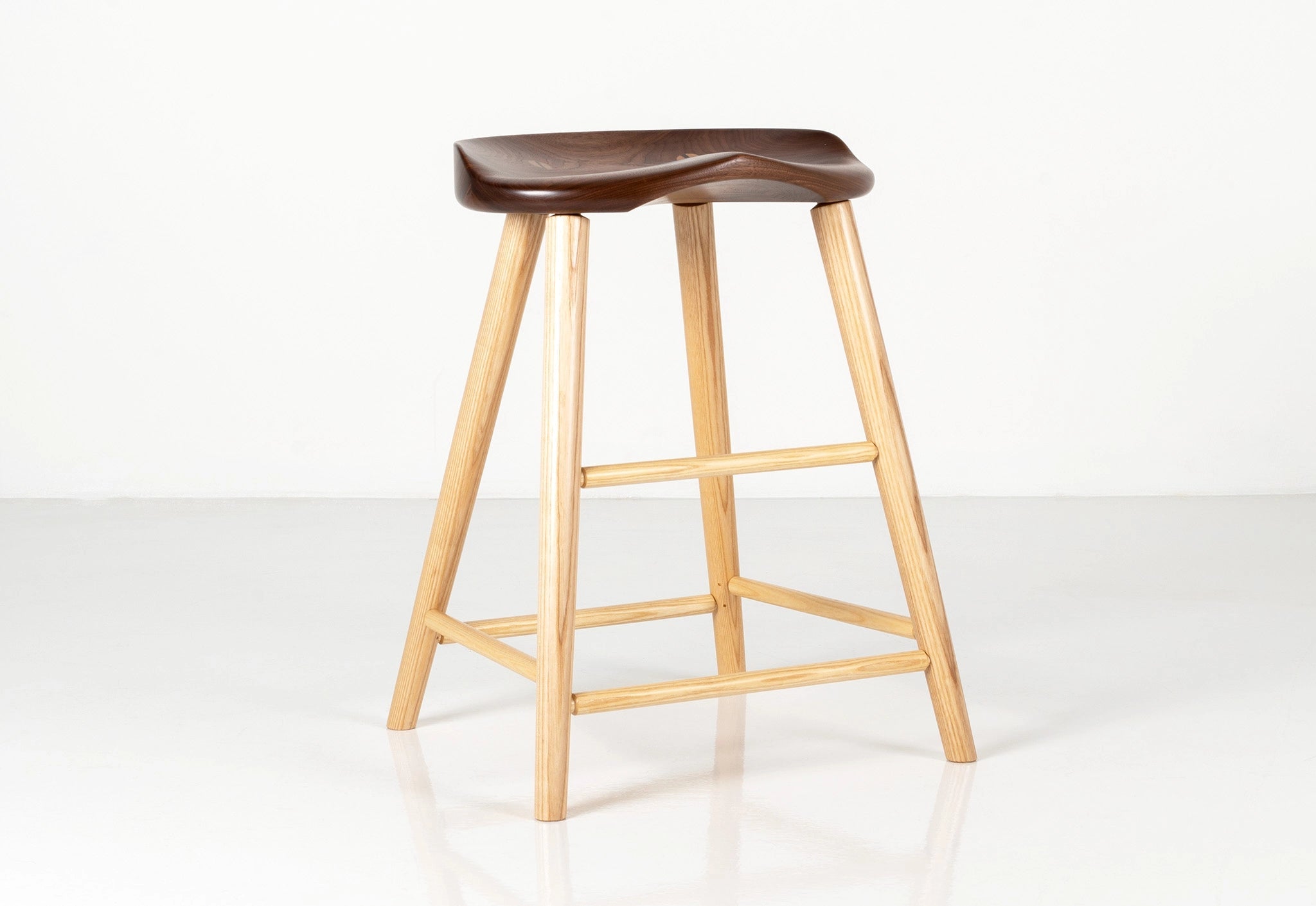 Wooden bar stool with a dark brown seat on a white background