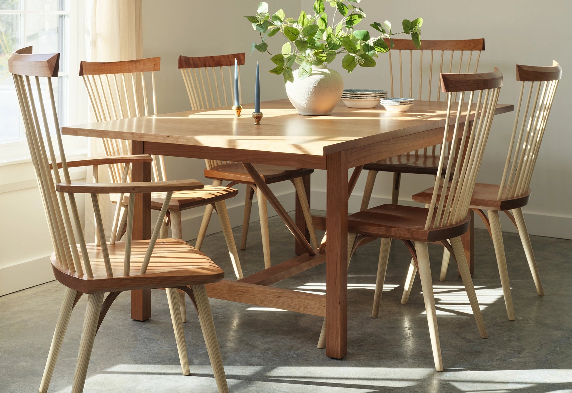 Wooden dining table with chairs in a well-lit room