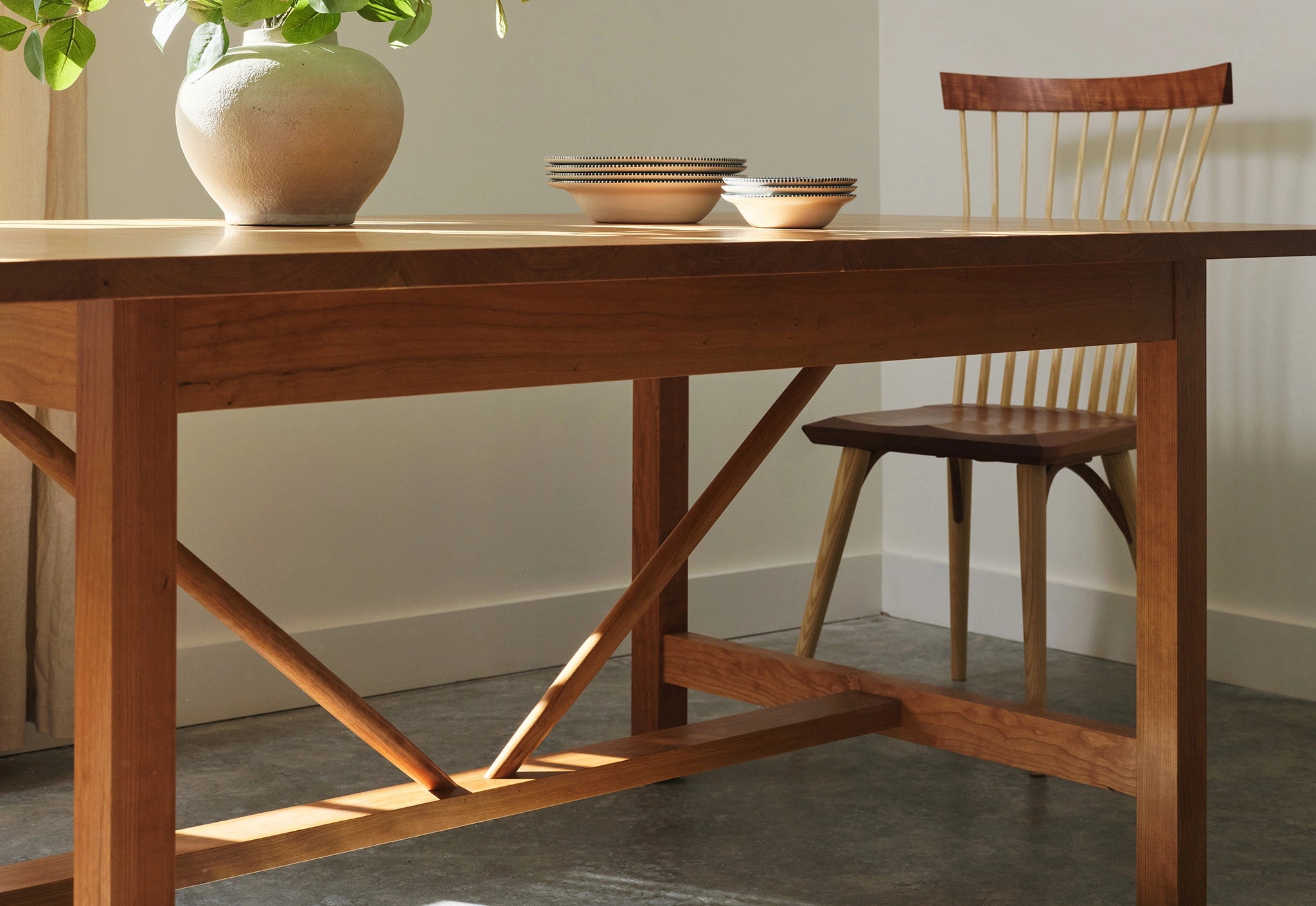 Wooden dining table with a chair and decorative items in a room.
