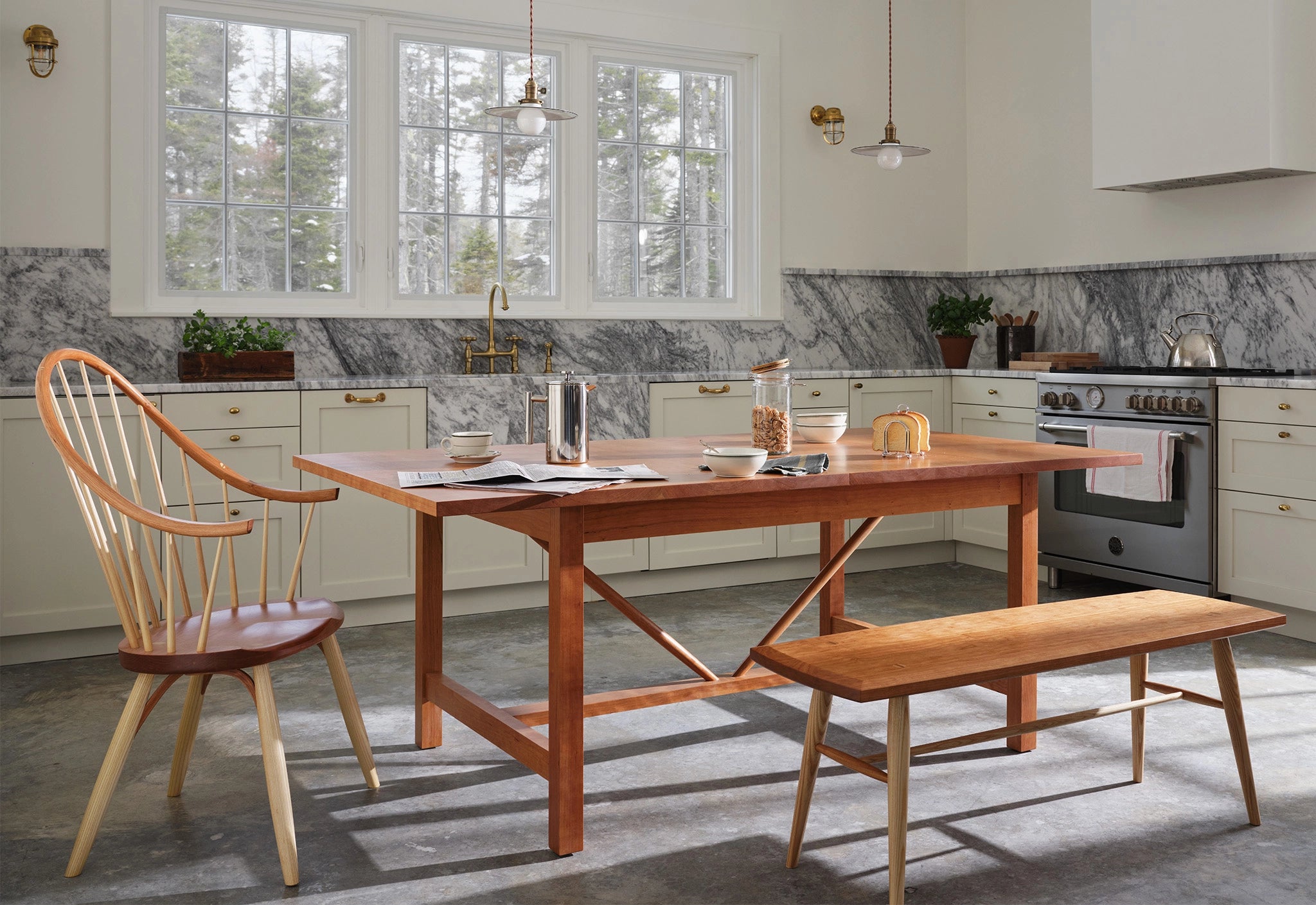 Wooden dining table with chairs and a bench in a modern kitchen.