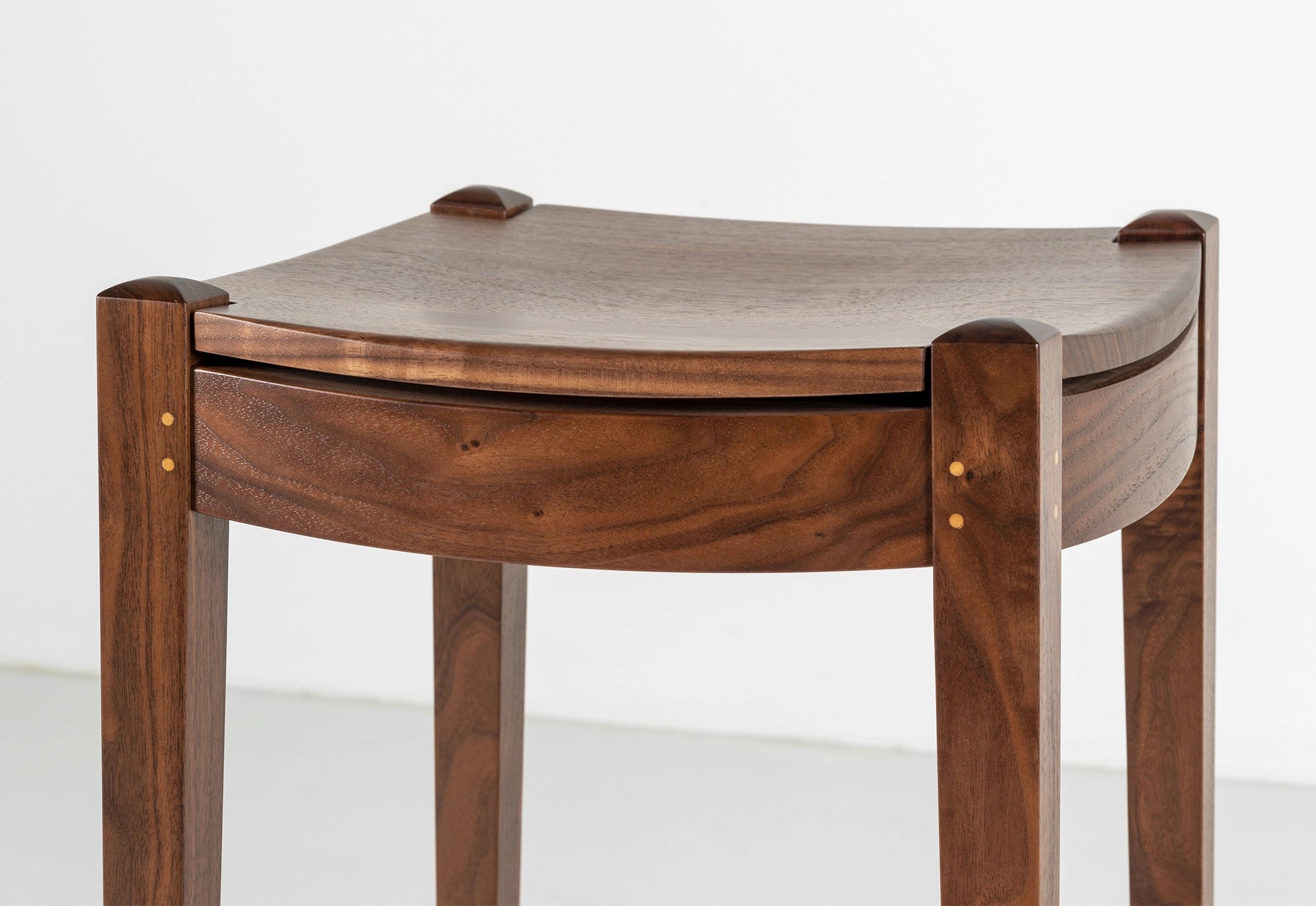 Wooden table with a square top and rounded sides on a white background