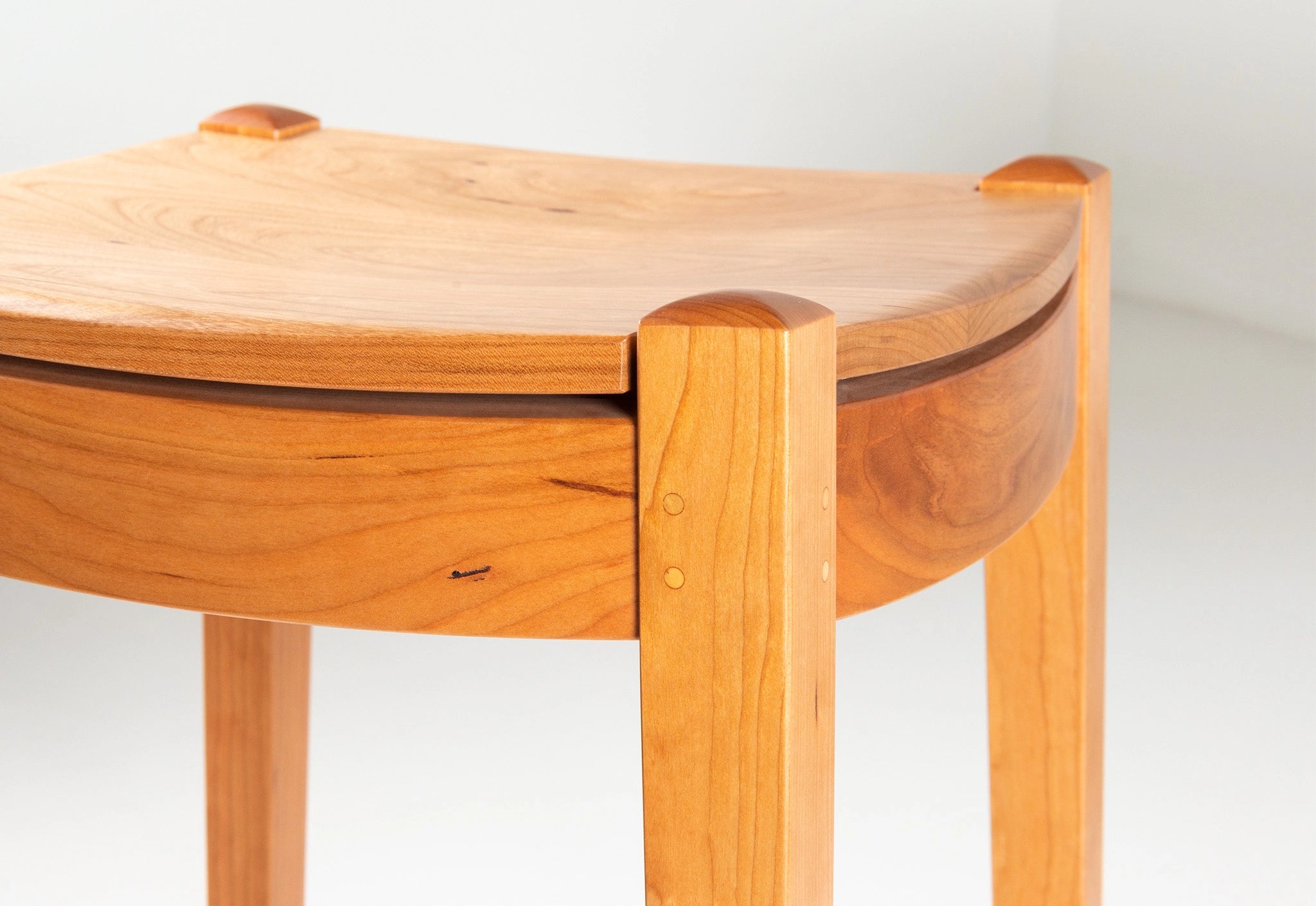 Wooden stool with a light finish on a white background