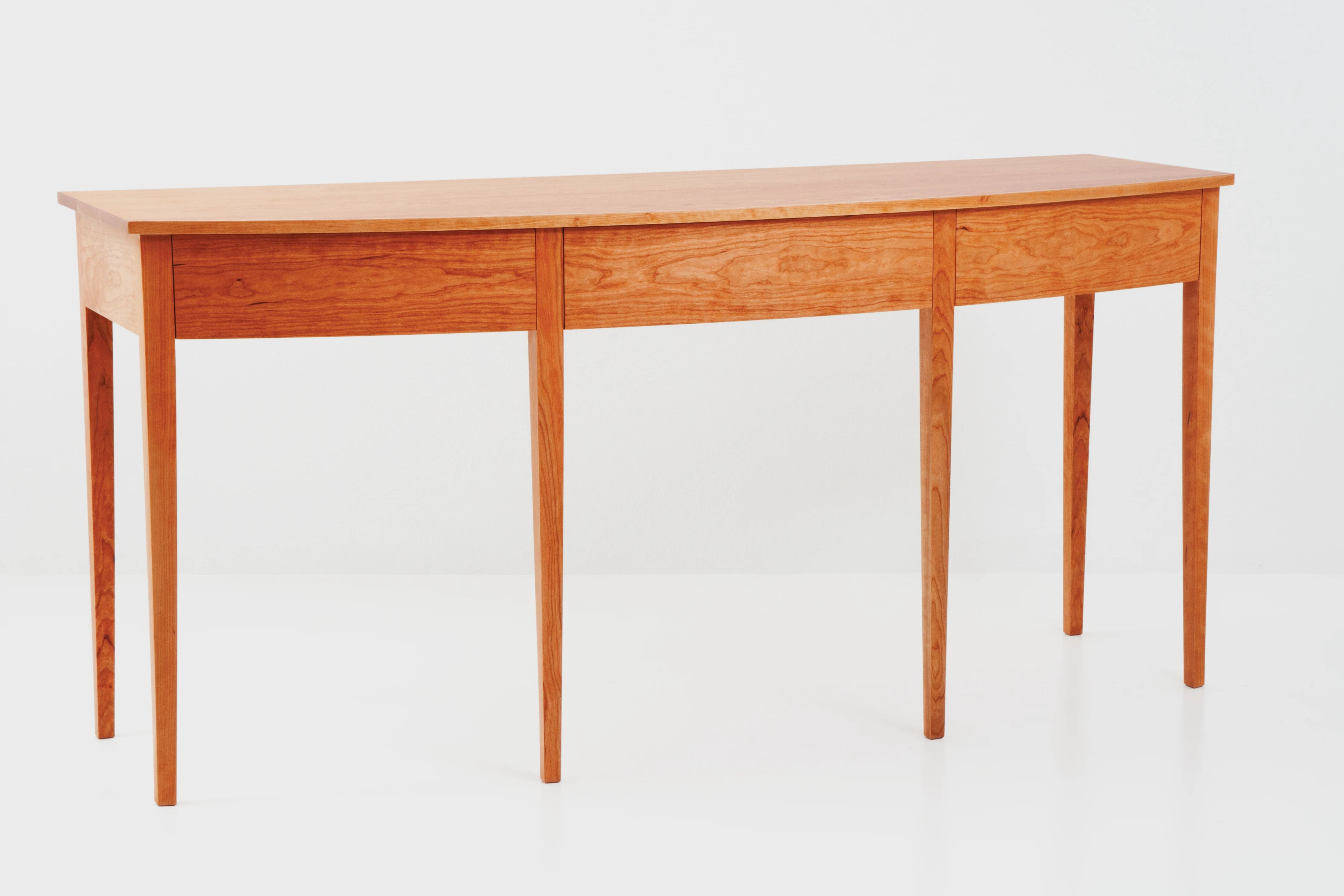 Wooden desk with three drawers on a white background