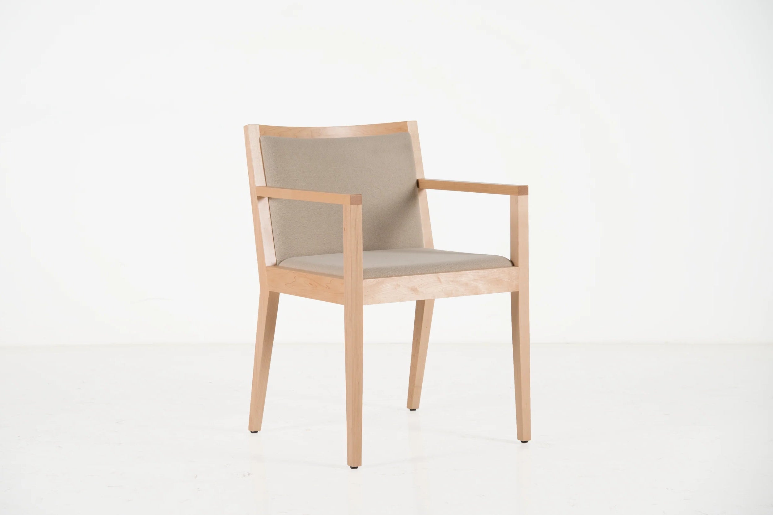 Wooden chair with beige cushion on a white background