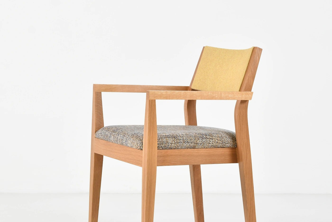 Wooden chair with a patterned cushion on a white background