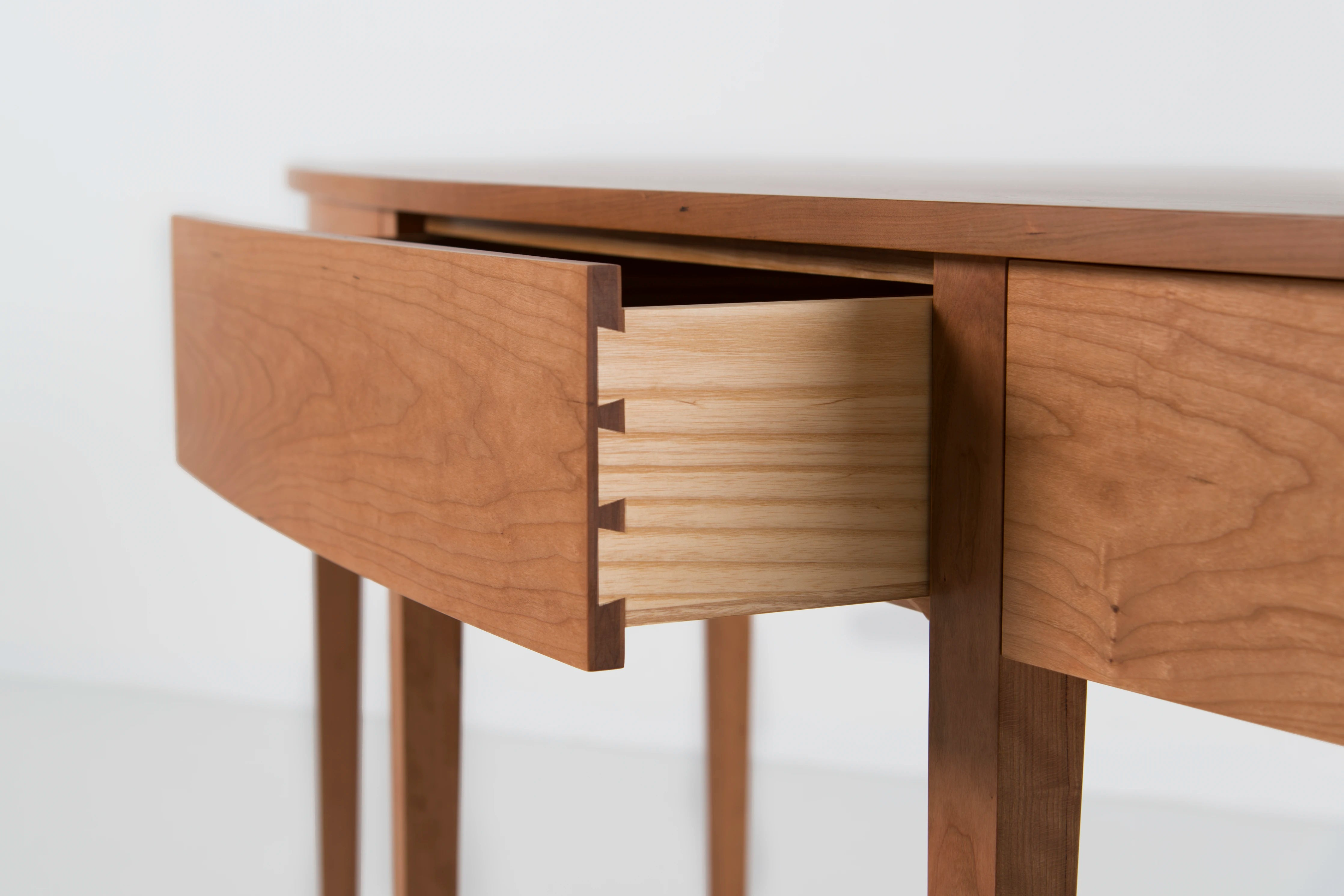 Wooden table with a drawer open on a white background