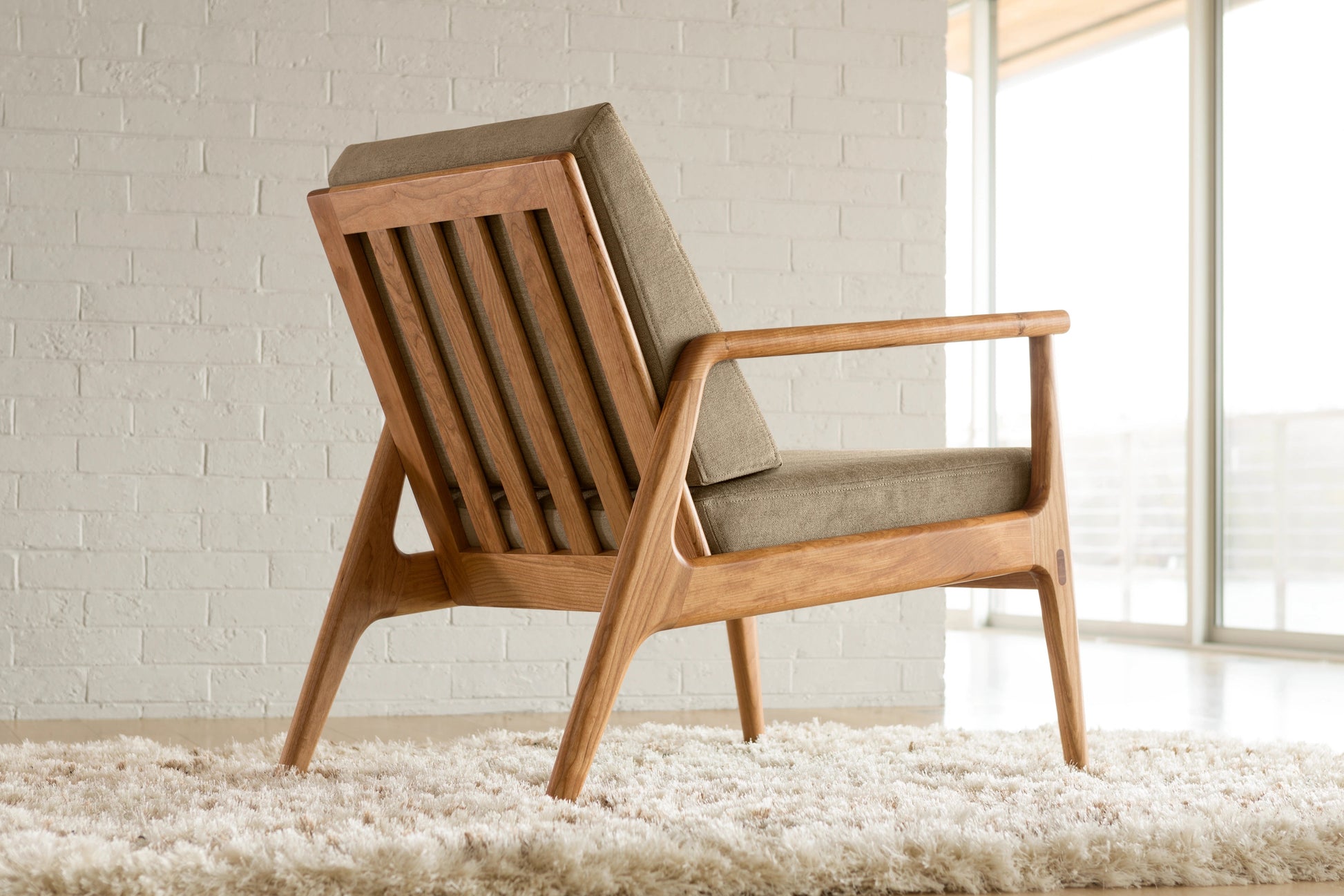 Cherry wood chair with upholstered seat in a light room.