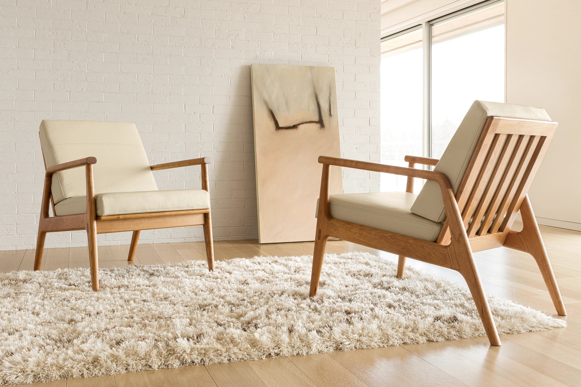 Modern living room with wooden chairs on a light wood floor.