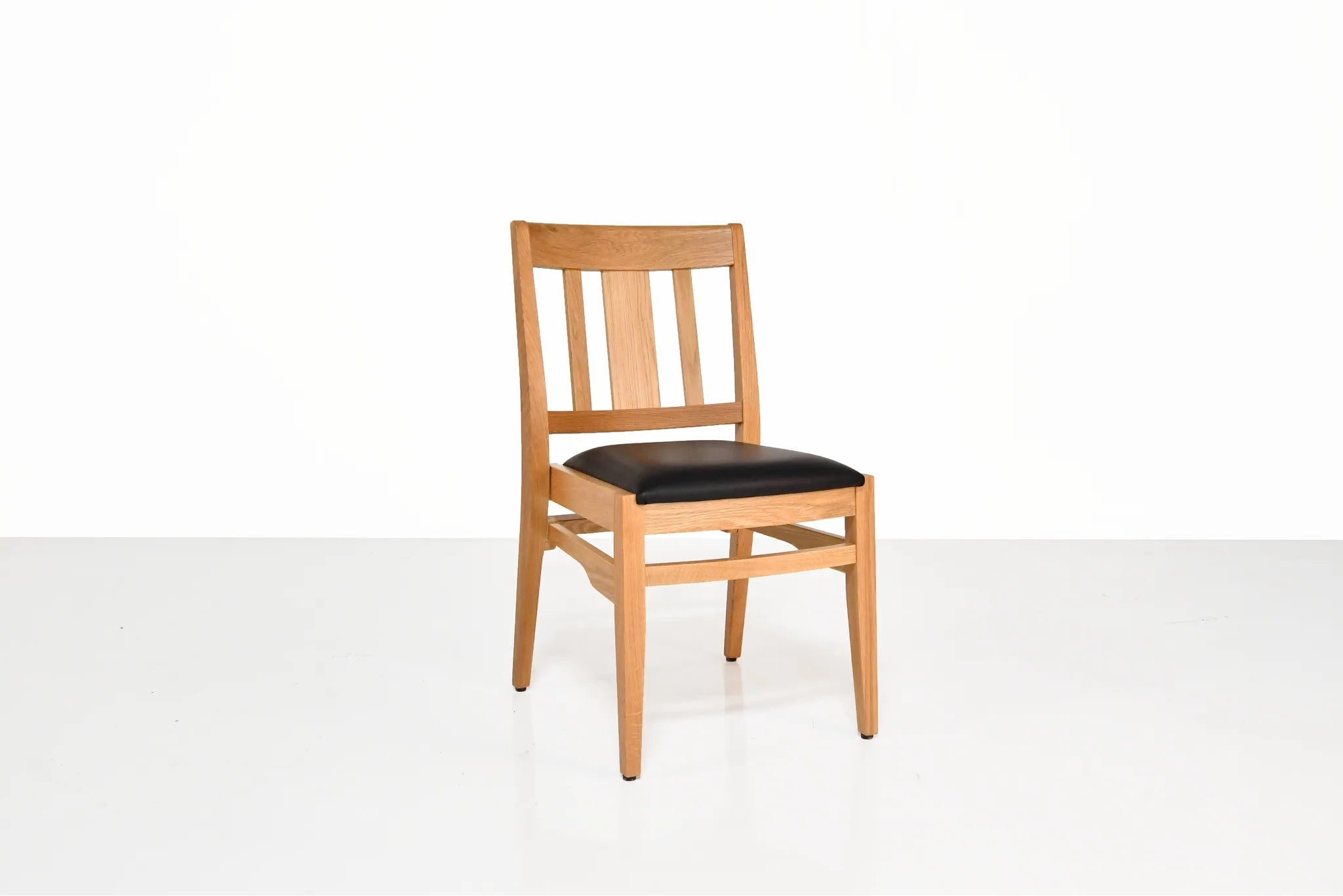 Wooden chair with a black seat on a white background