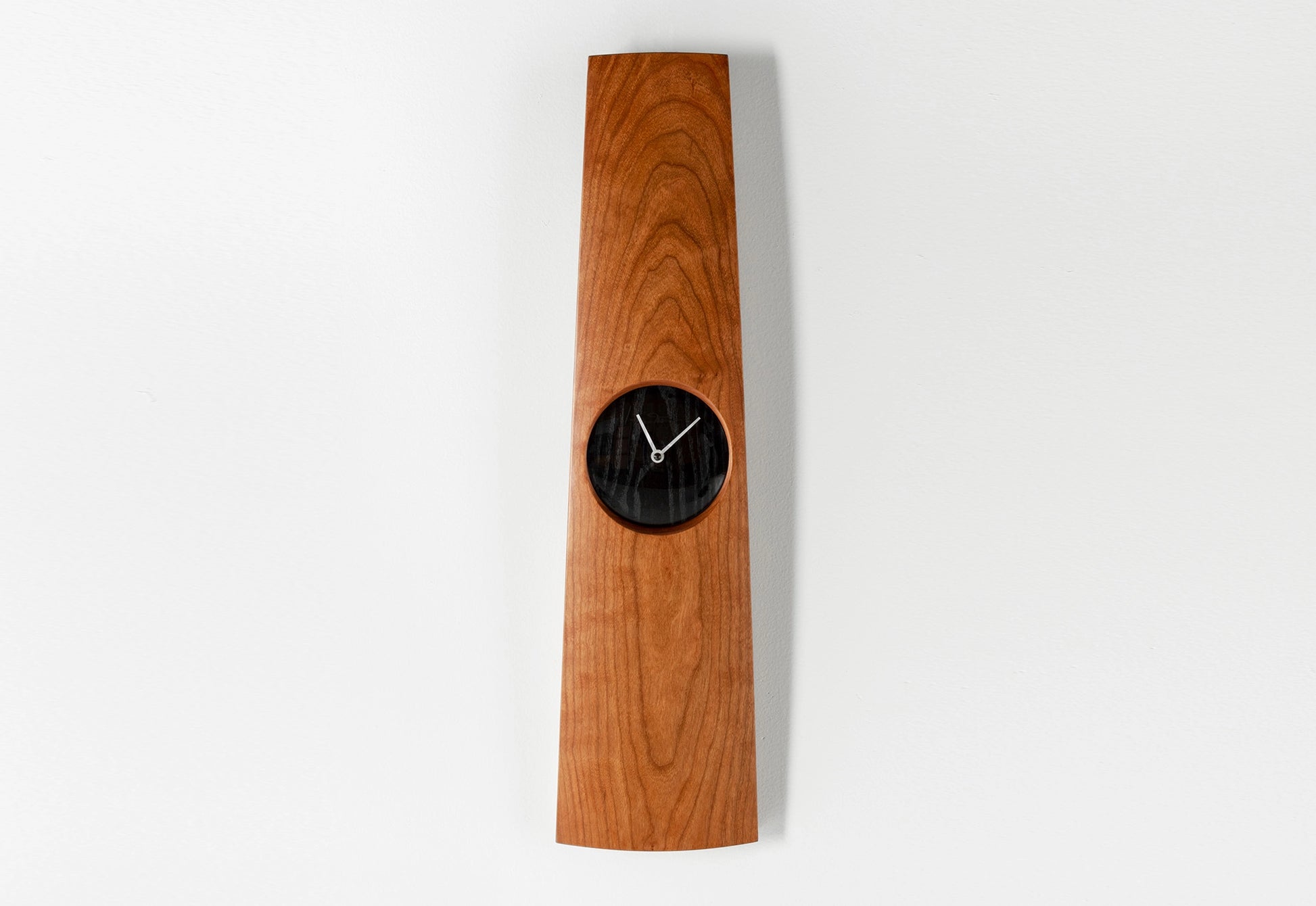 Wooden wall clock with a black clock face on a white background