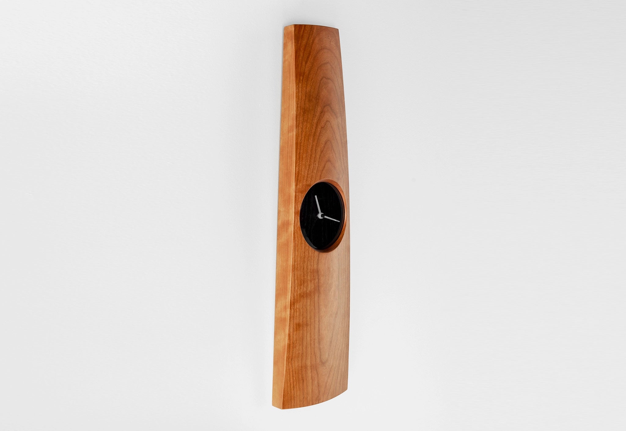 Wooden wall clock with a black clock face on a white background