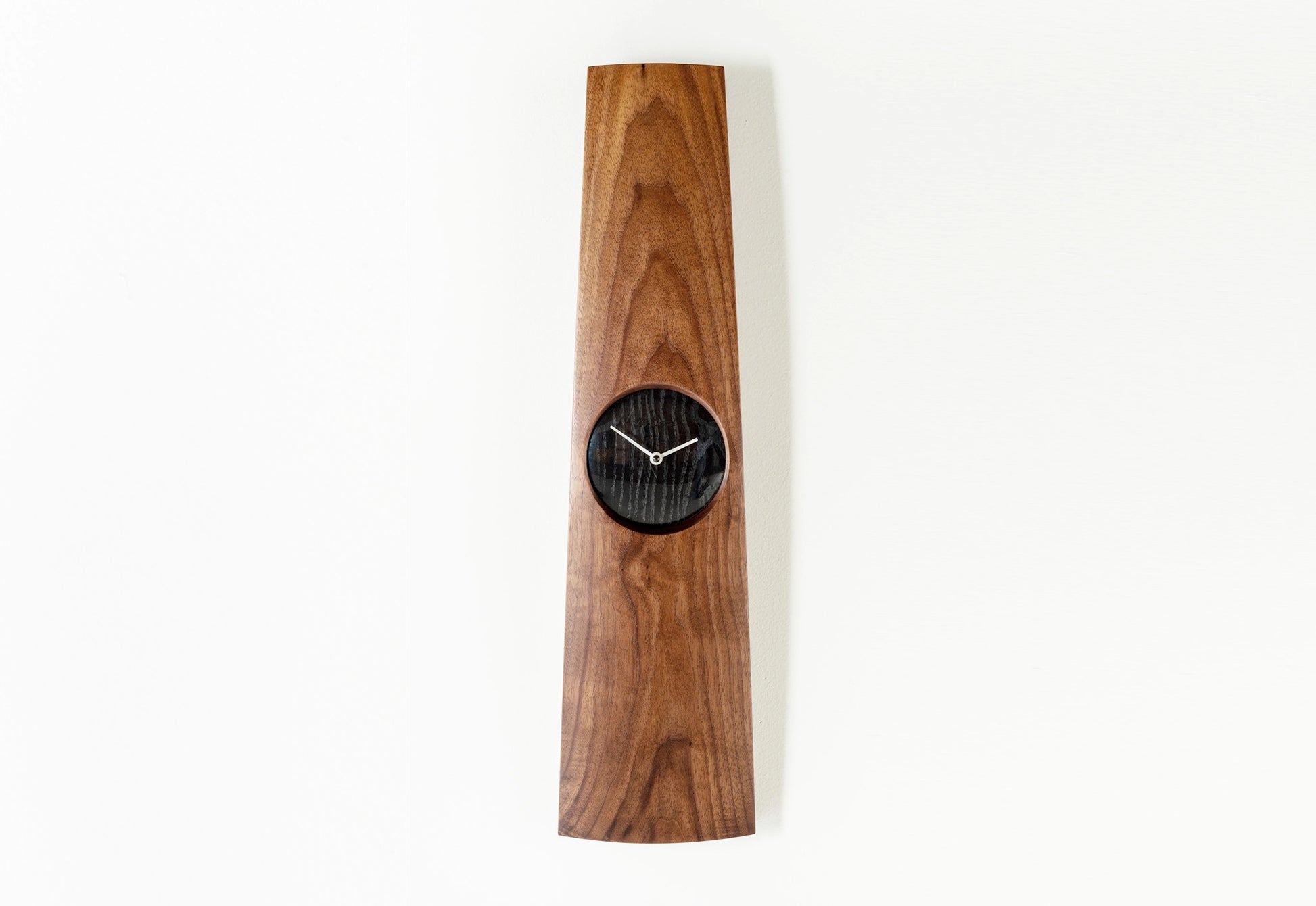 Wooden wall clock with black clock face on a white background