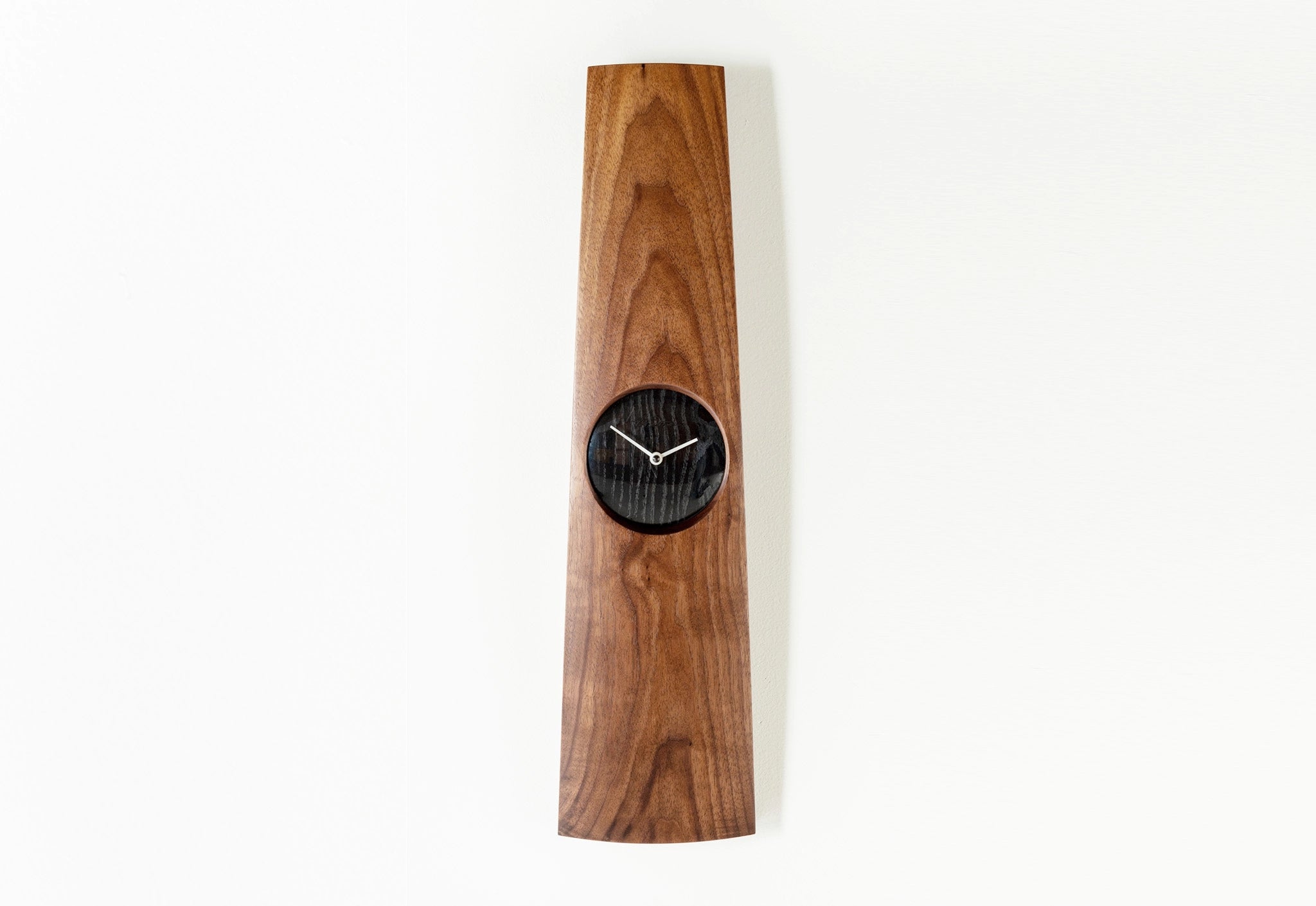 Wooden wall clock with black clock face on a white background