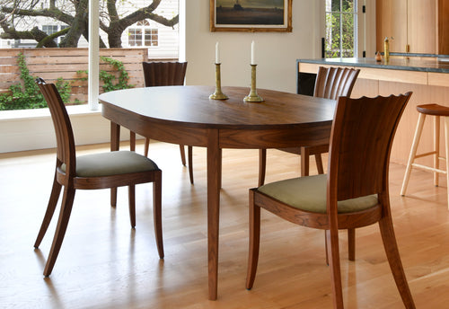 Wooden dining table with chairs in a well-lit room