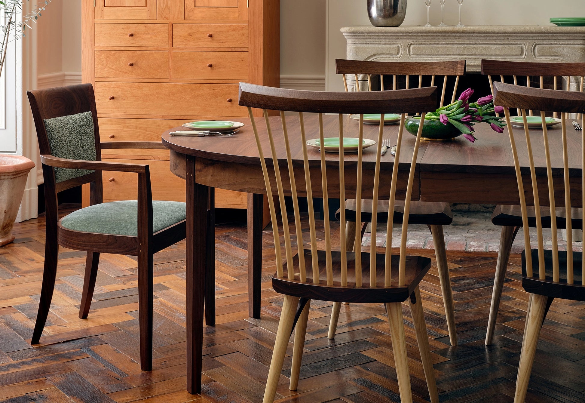 Dining room with wooden table and chairs on a parquet floor.