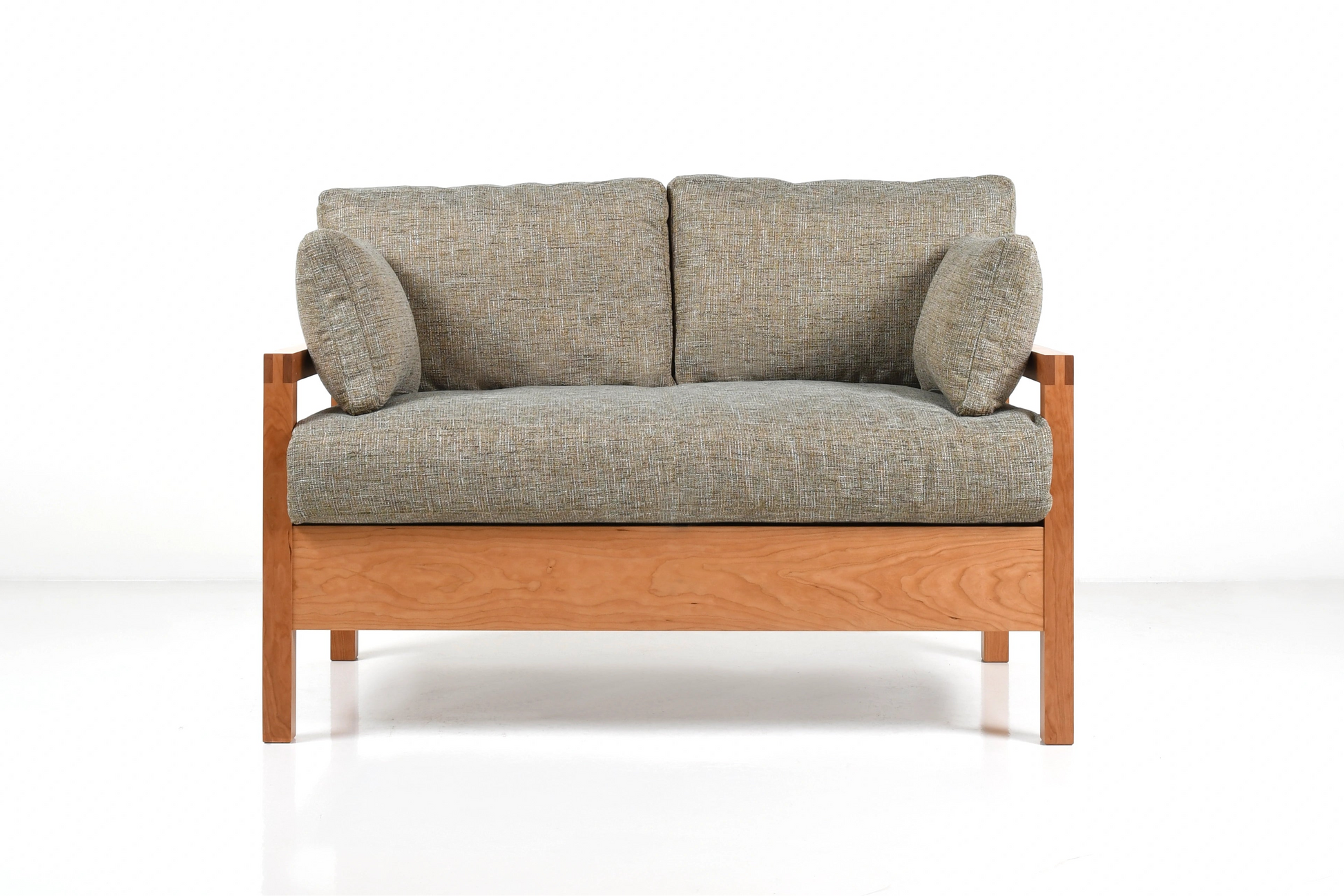 Tonal upholstered sofa with wooden frame on a white background