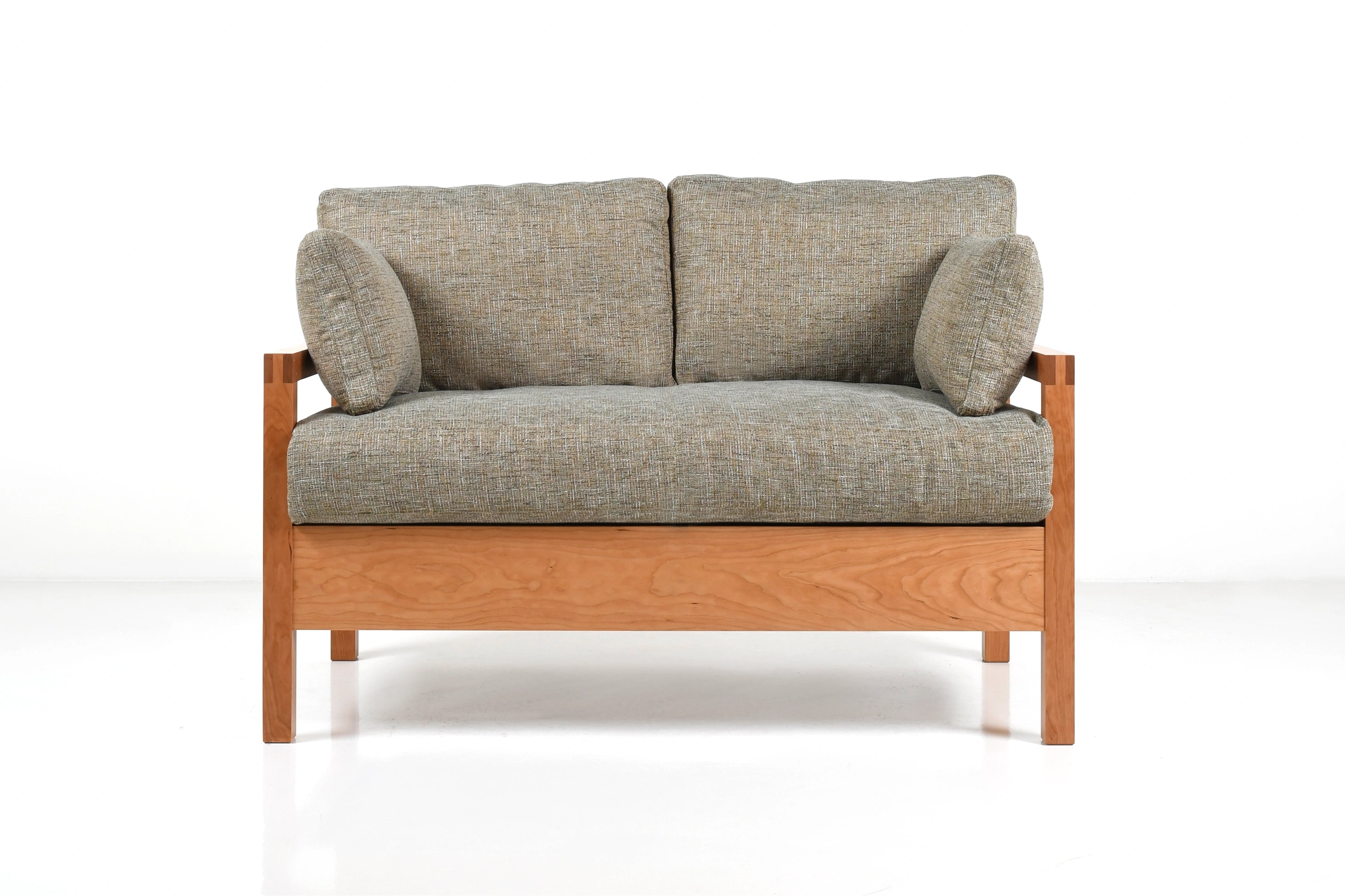Tonal upholstered sofa with wooden frame on a white background