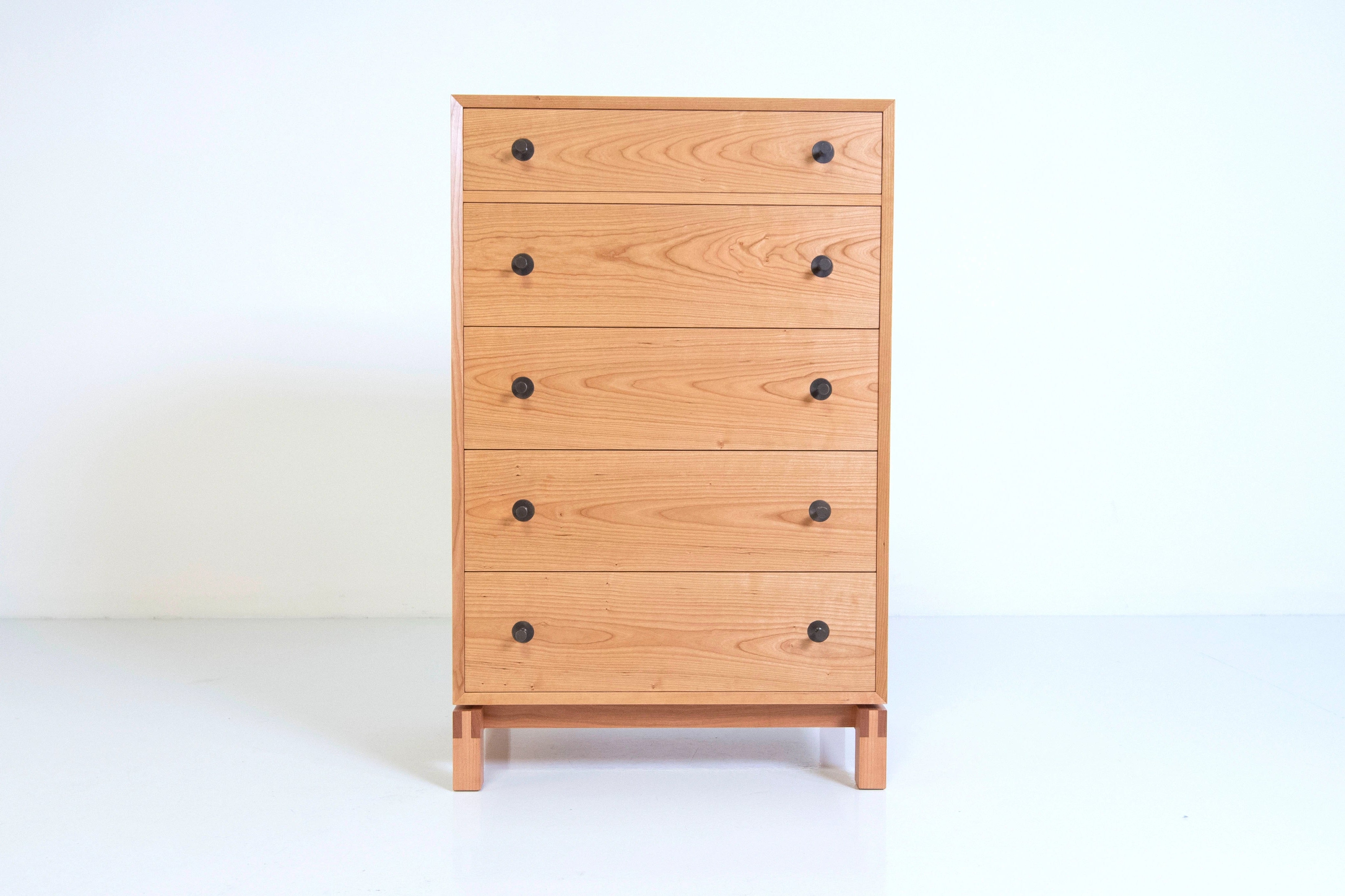 Wooden dresser with five drawers on a white background