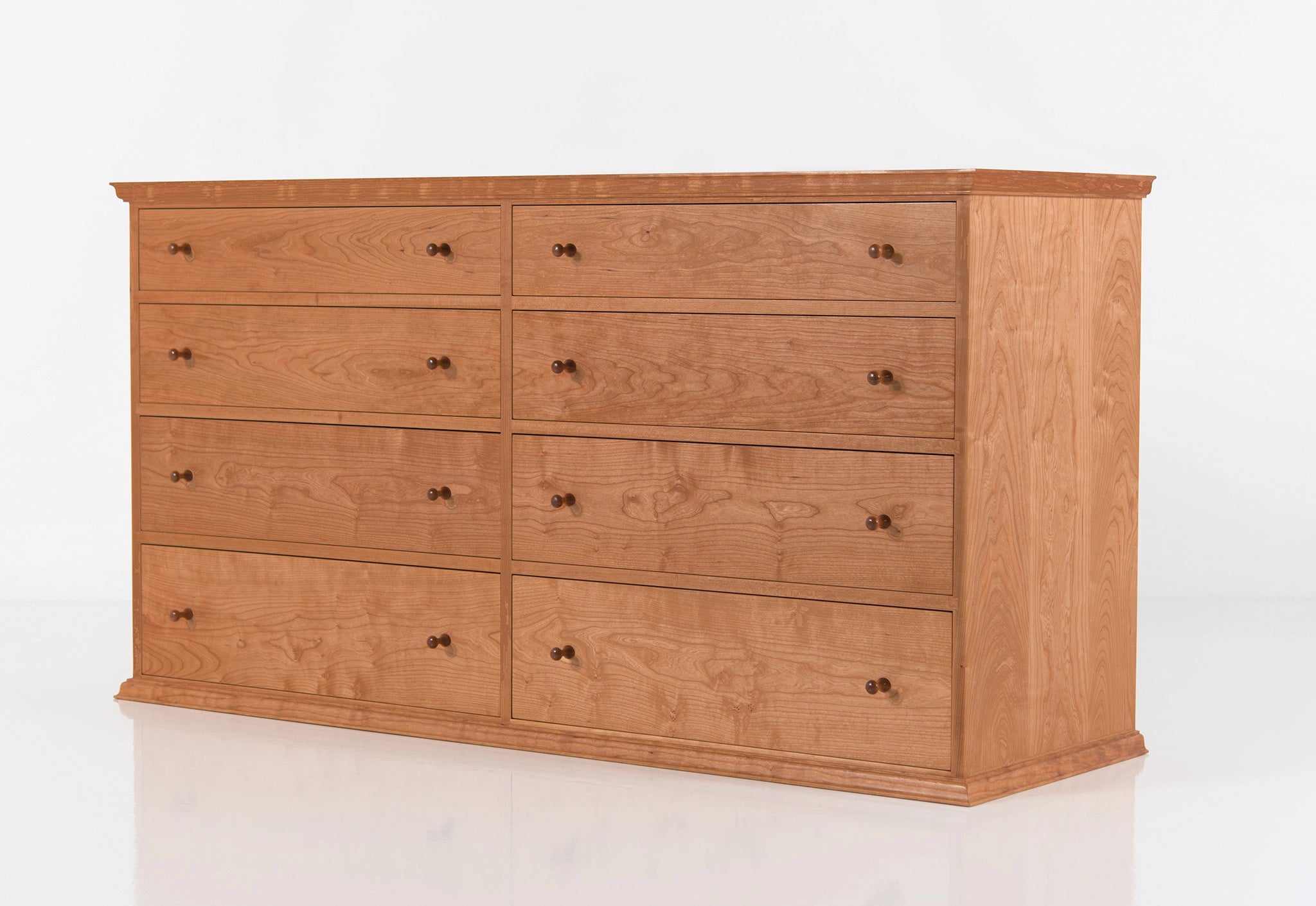 Wooden dresser with multiple drawers on a white background