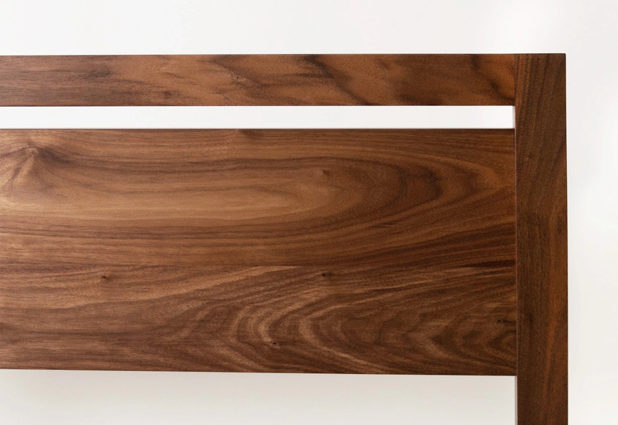 Close-up of a walnut wooden headboard with a white background