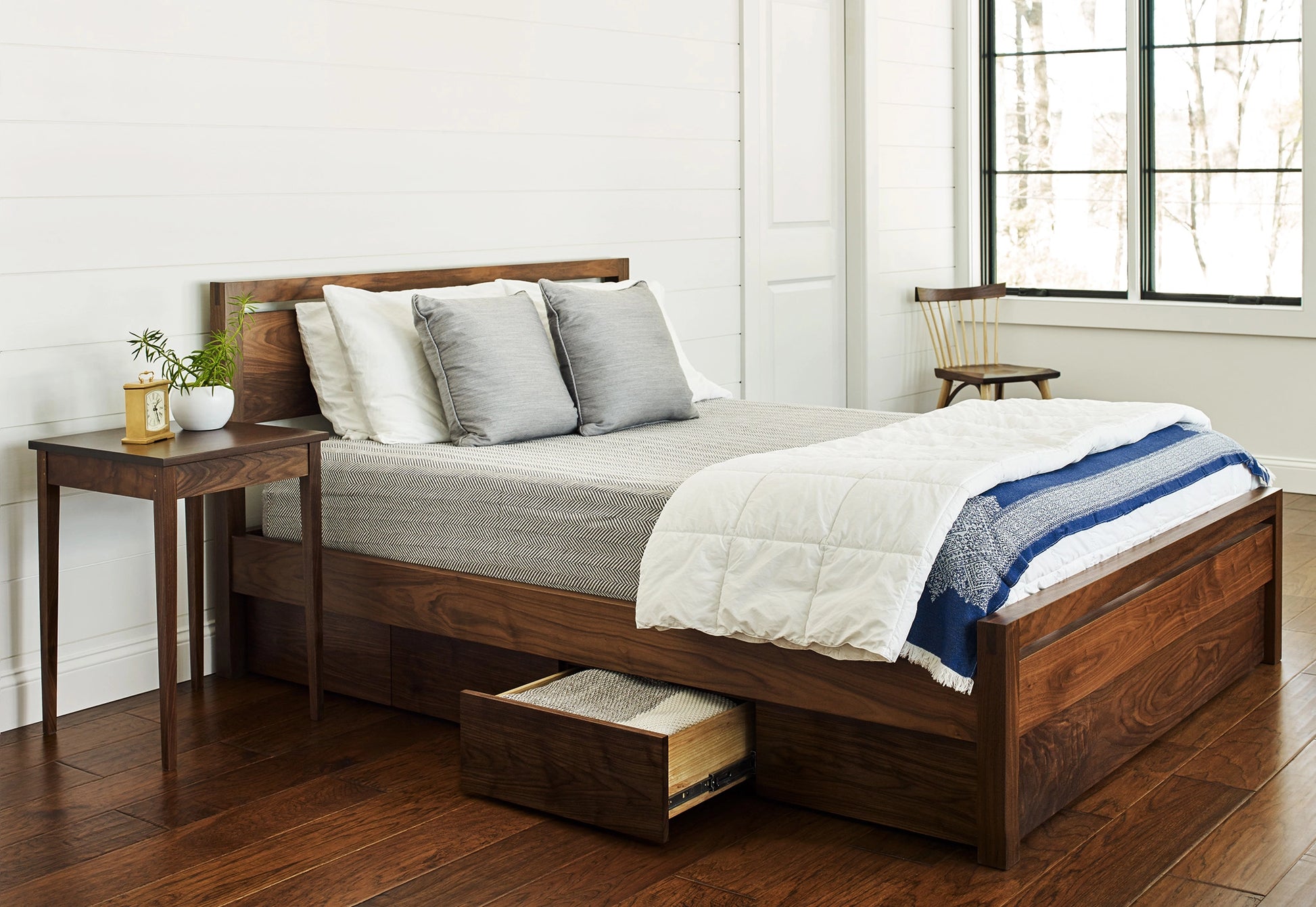 Wooden bed with storage drawers in a bedroom setting