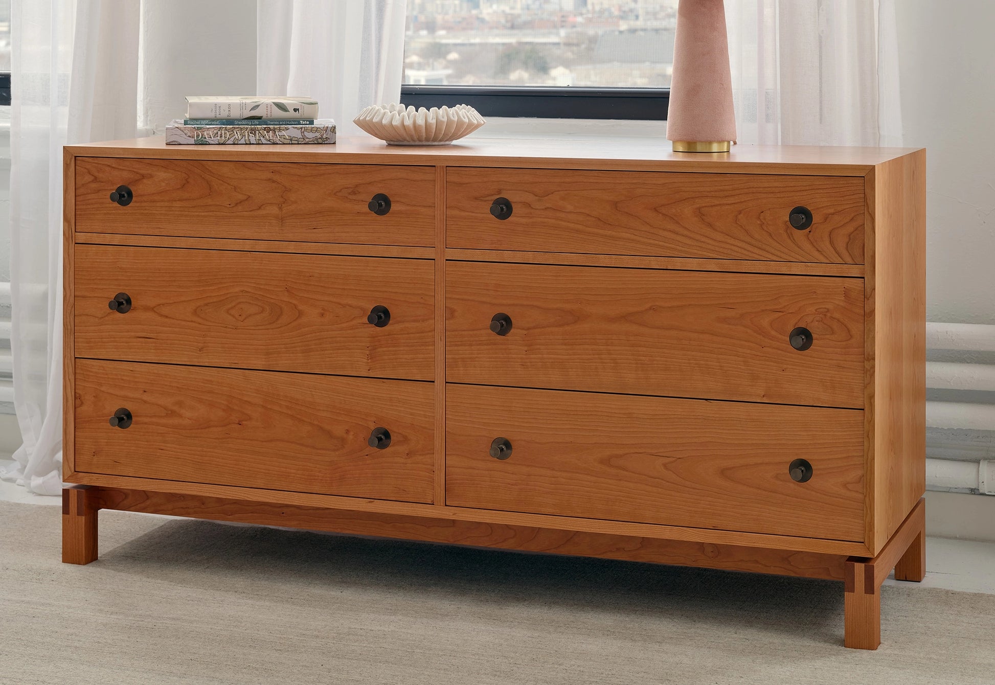 Wooden dresser with four drawers in a room setting