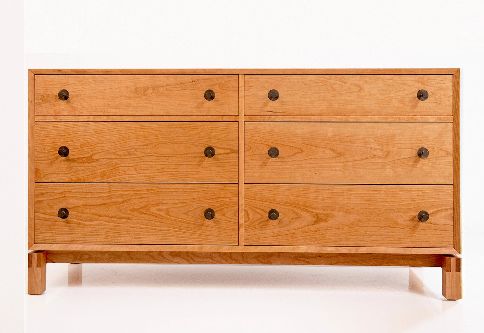 Wooden dresser with six drawers on a white background
