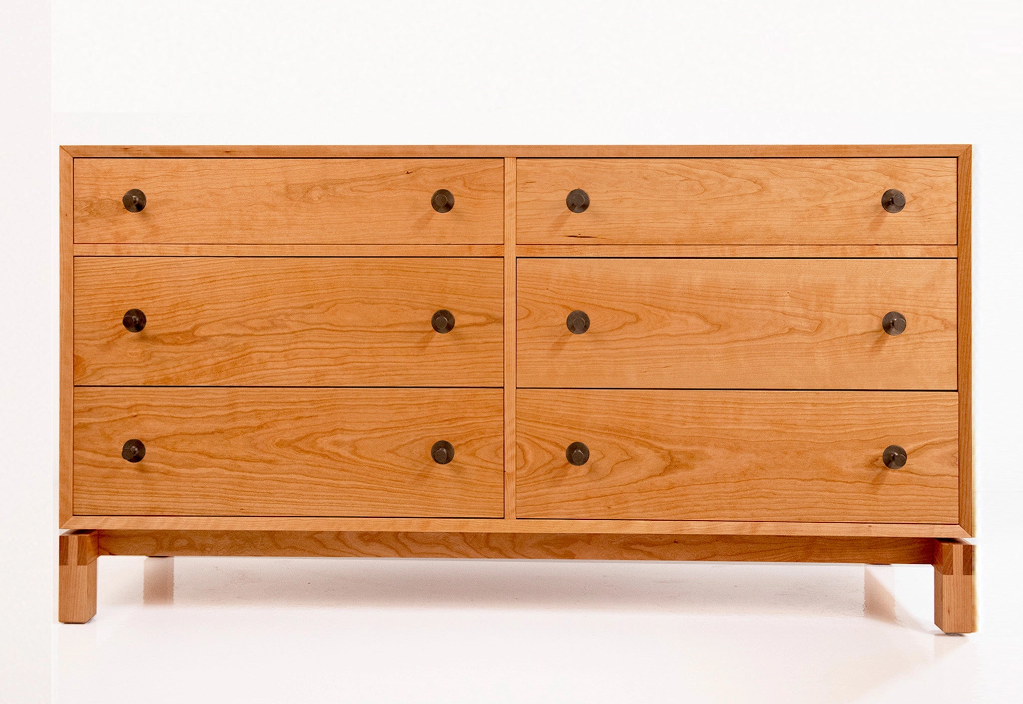Wooden dresser with six drawers on a white background