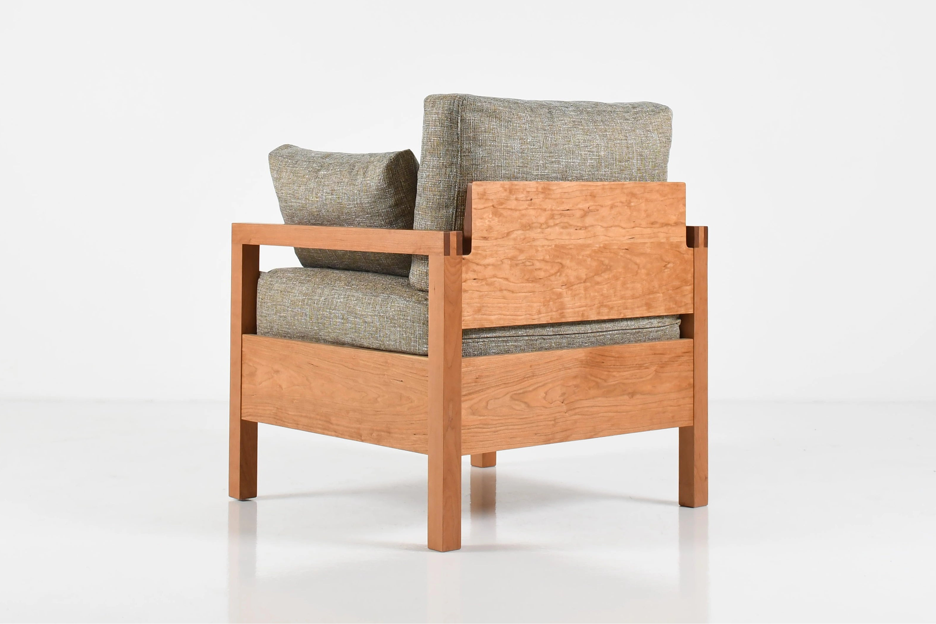 Wooden armchair with gray cushions on a white background