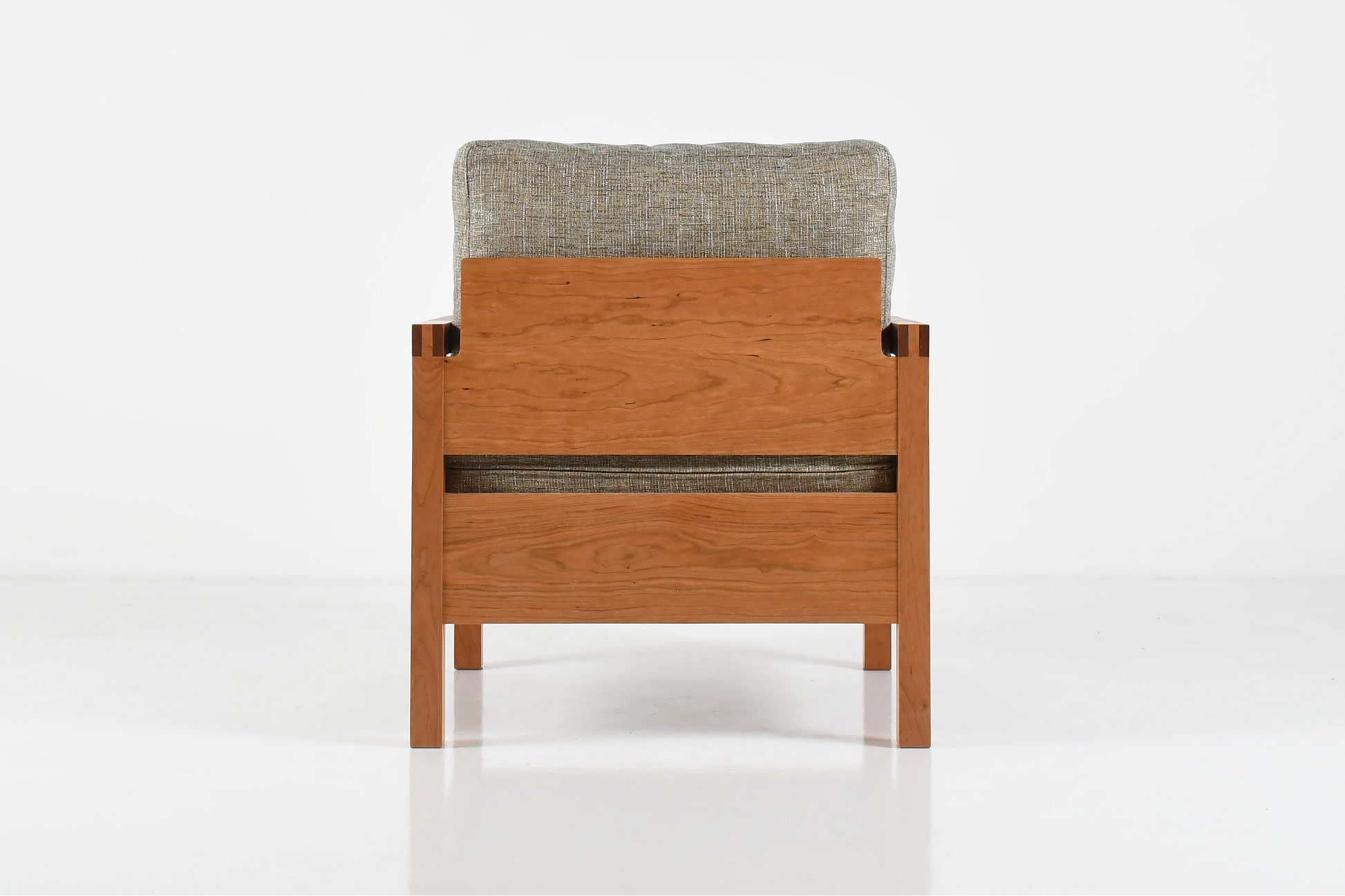 Wooden chair with gray cushion on a white background