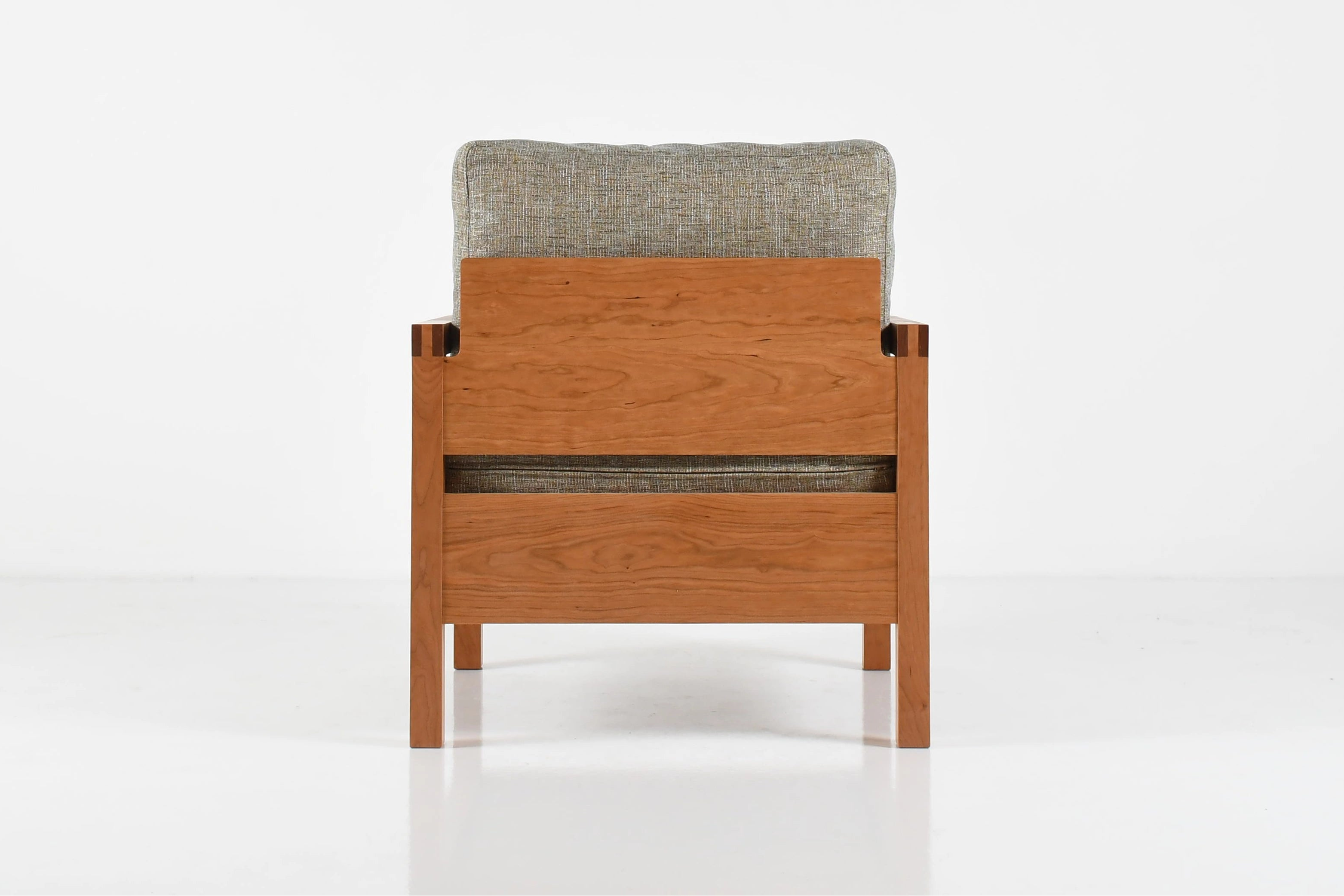 Wooden chair with gray cushion on a white background