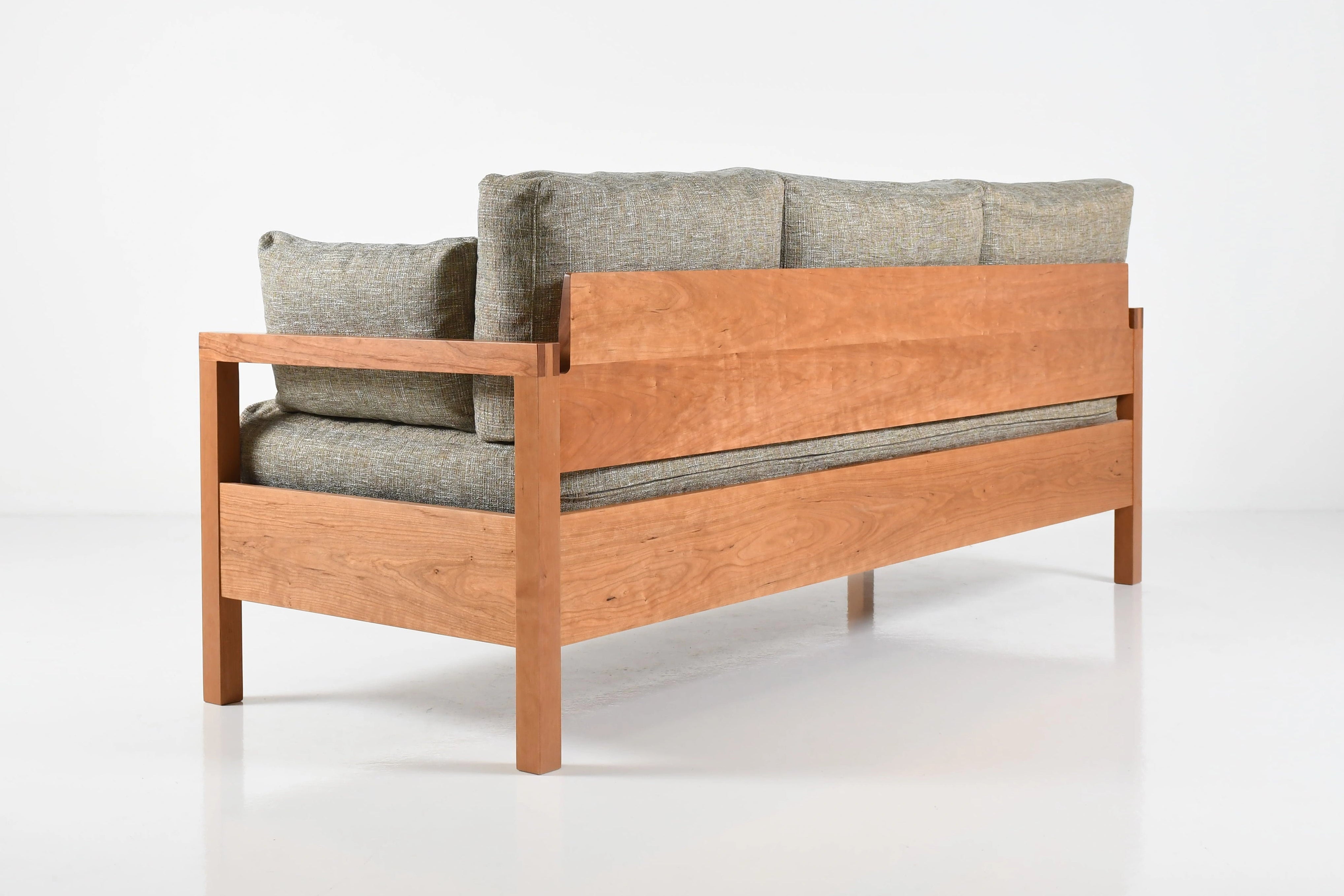 Wooden sofa with gray cushions on a white background