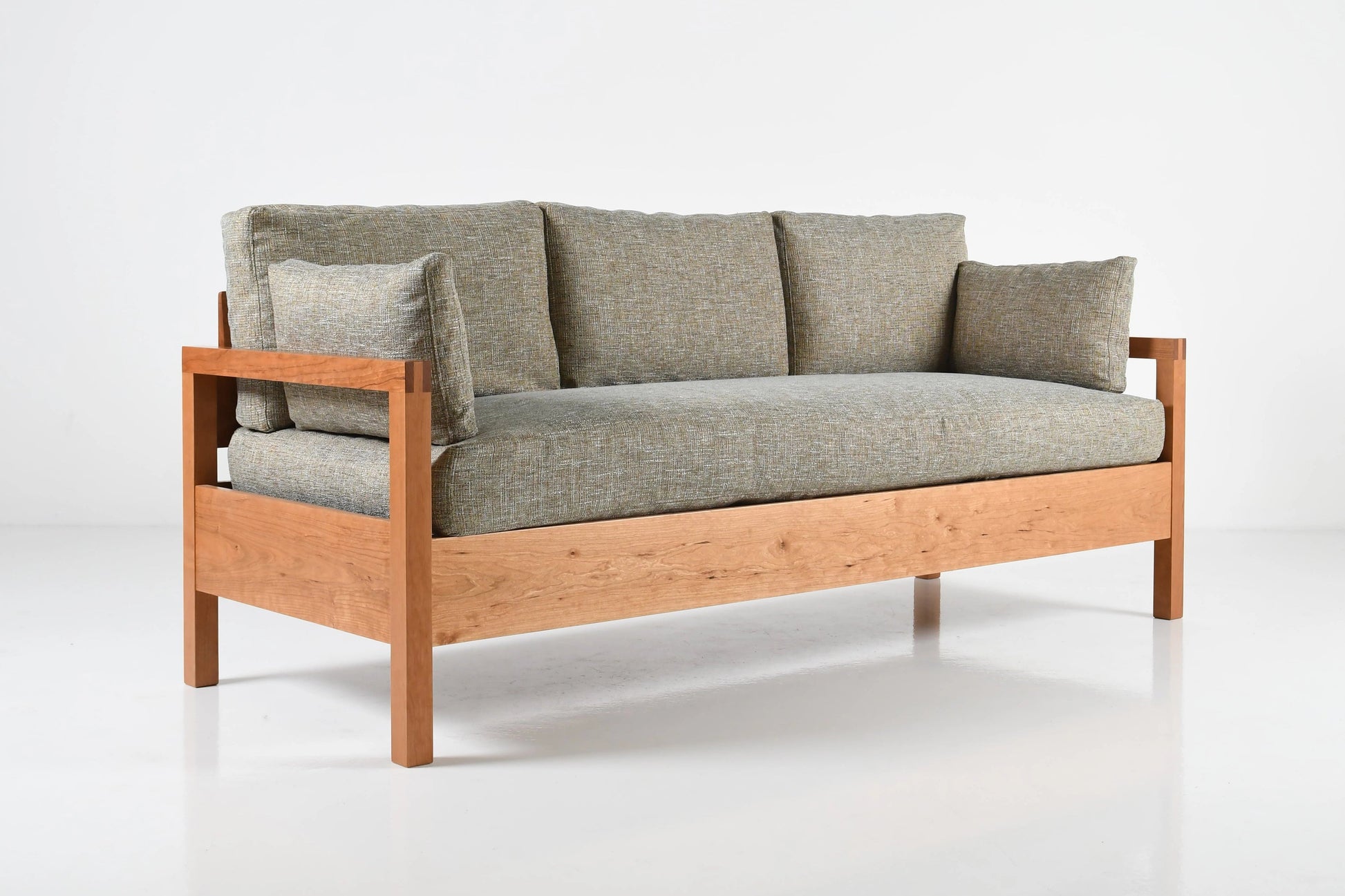Sofa with wooden frame and gray cushions on a white background