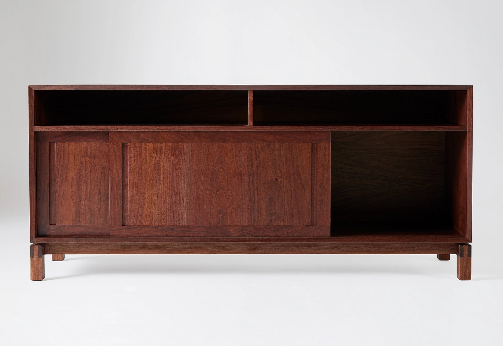 Wooden sideboard with open and closed compartments on a white background