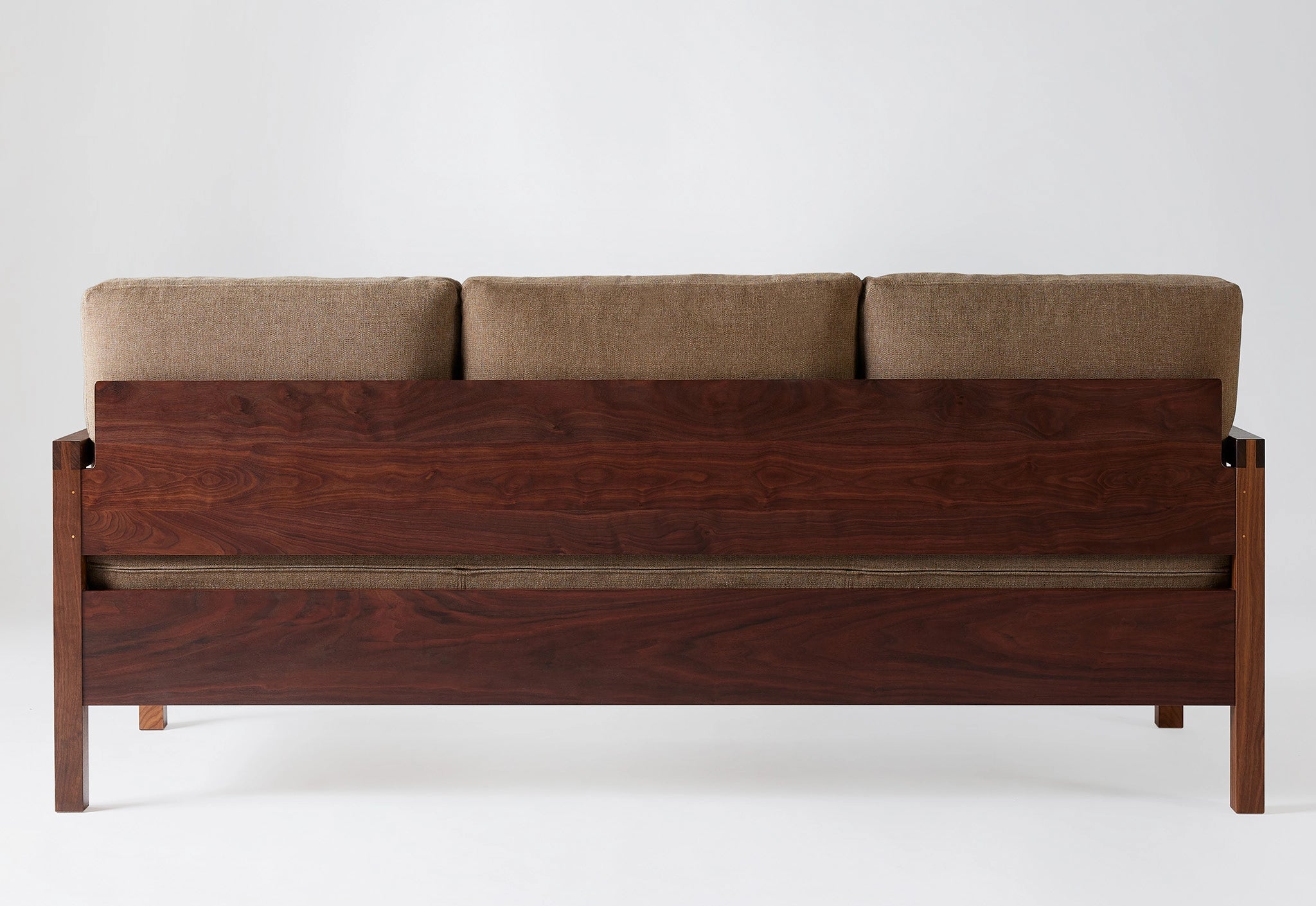 Wooden framed sofa with brown upholstery on a white background.