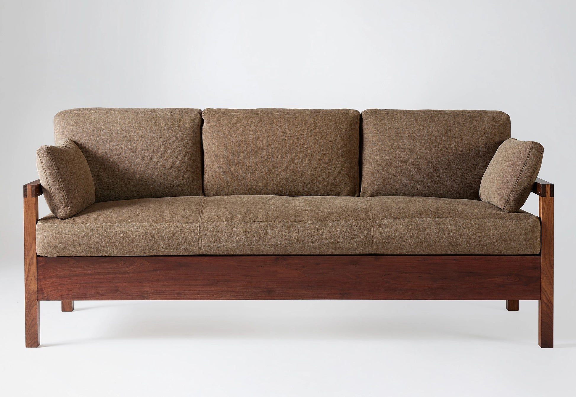Wooden framed sofa with brown upholstery on a white background.