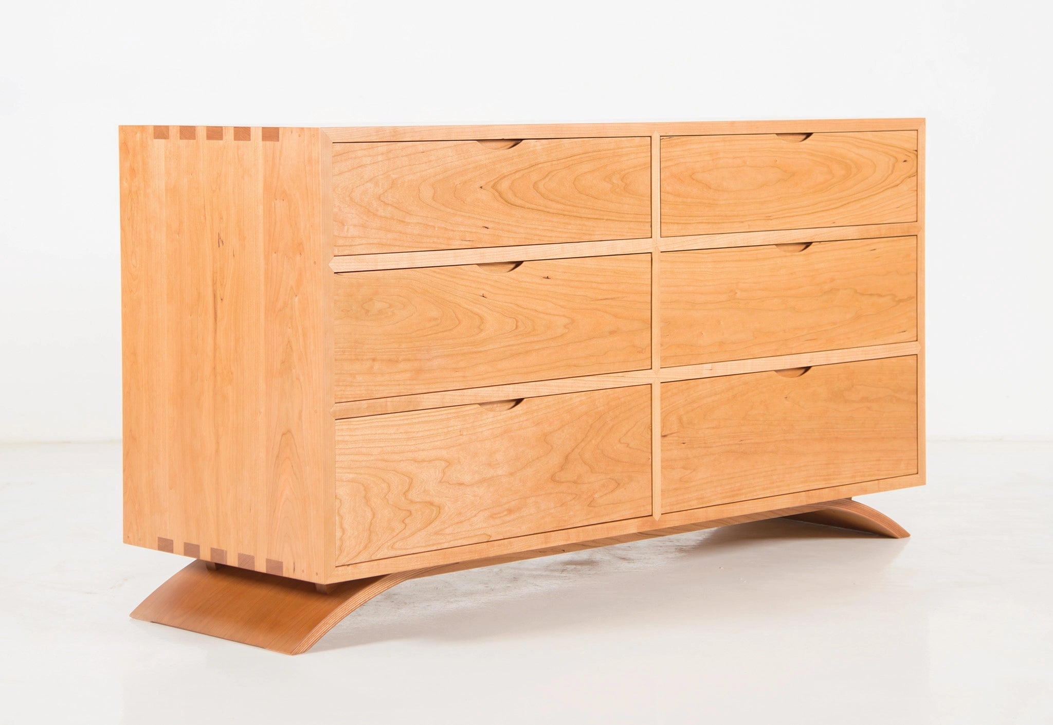 Wooden dresser with six drawers on a white background