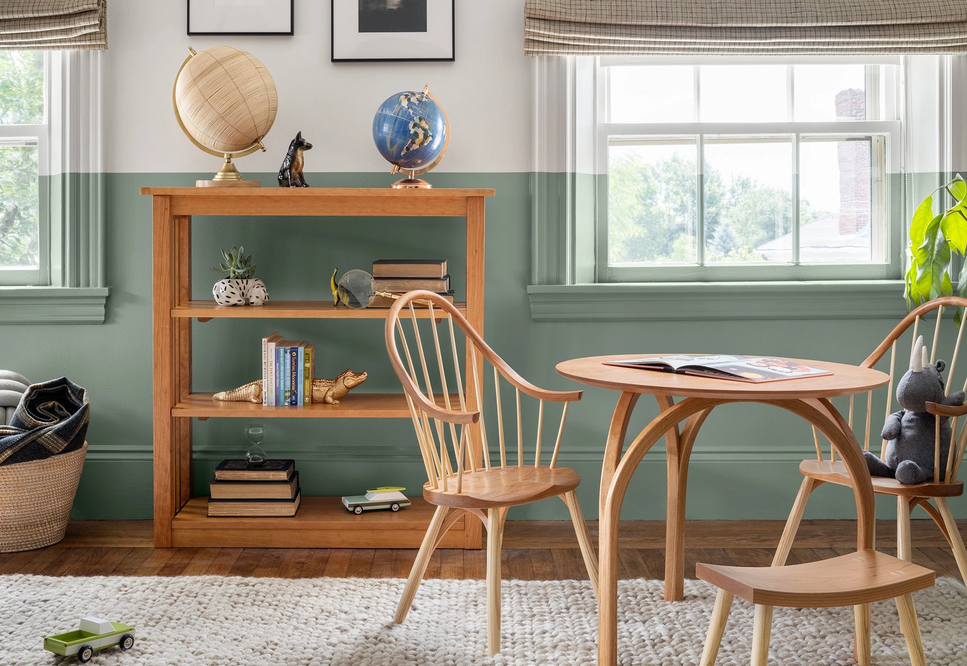Wooden bookshelf with decorative items in a room with chairs and a table.