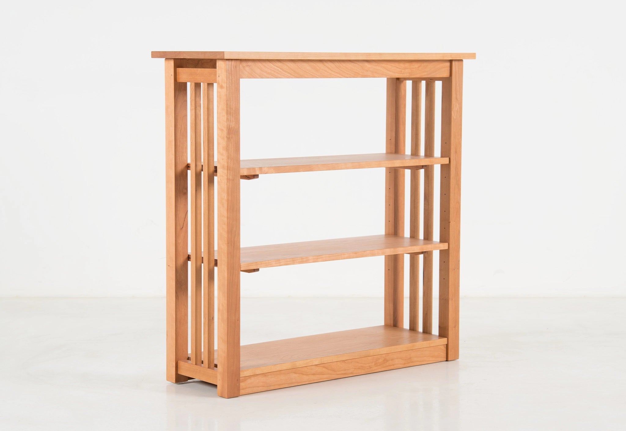 Wooden bookshelf with three shelves on a white background