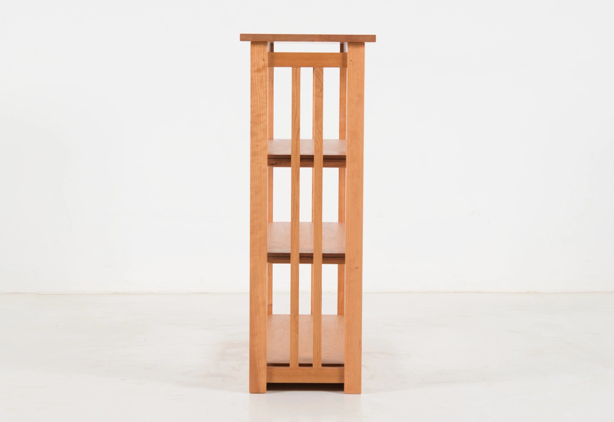 Wooden bookshelf with three shelves on a white background